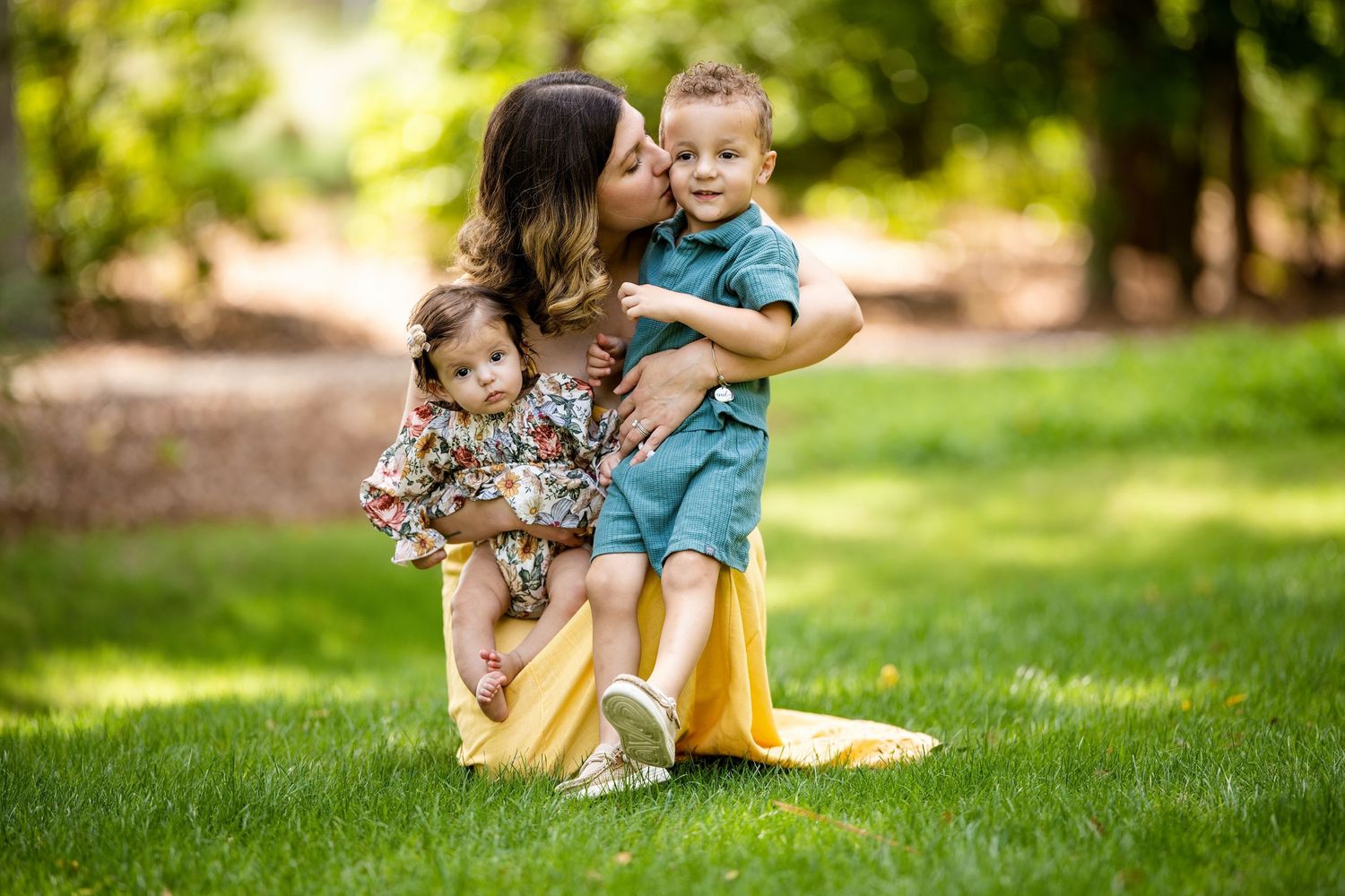 family of three cuddling in a local park in penscola, florida
