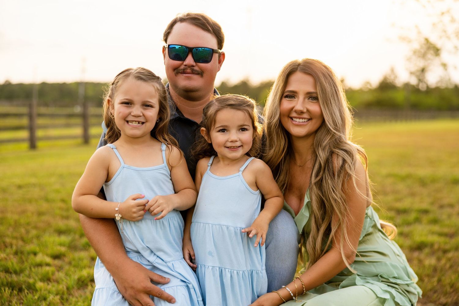 family of four snuggling under the golden sun in Destin at a park