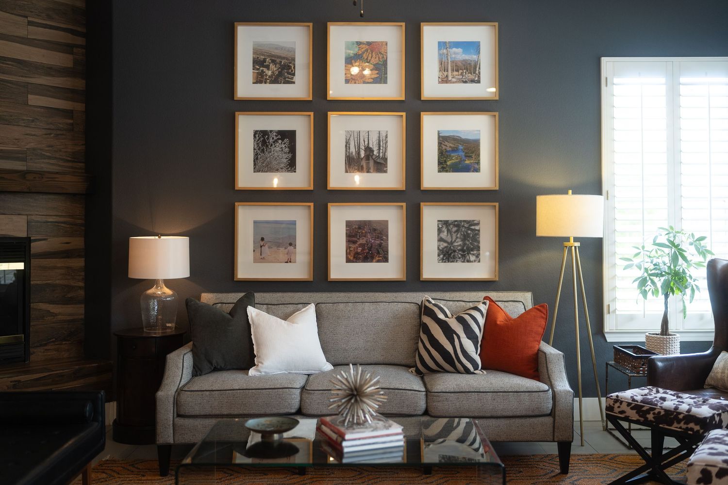 Contemporary living room with dark walls featuring gallery wall art and modern furniture arrangement.