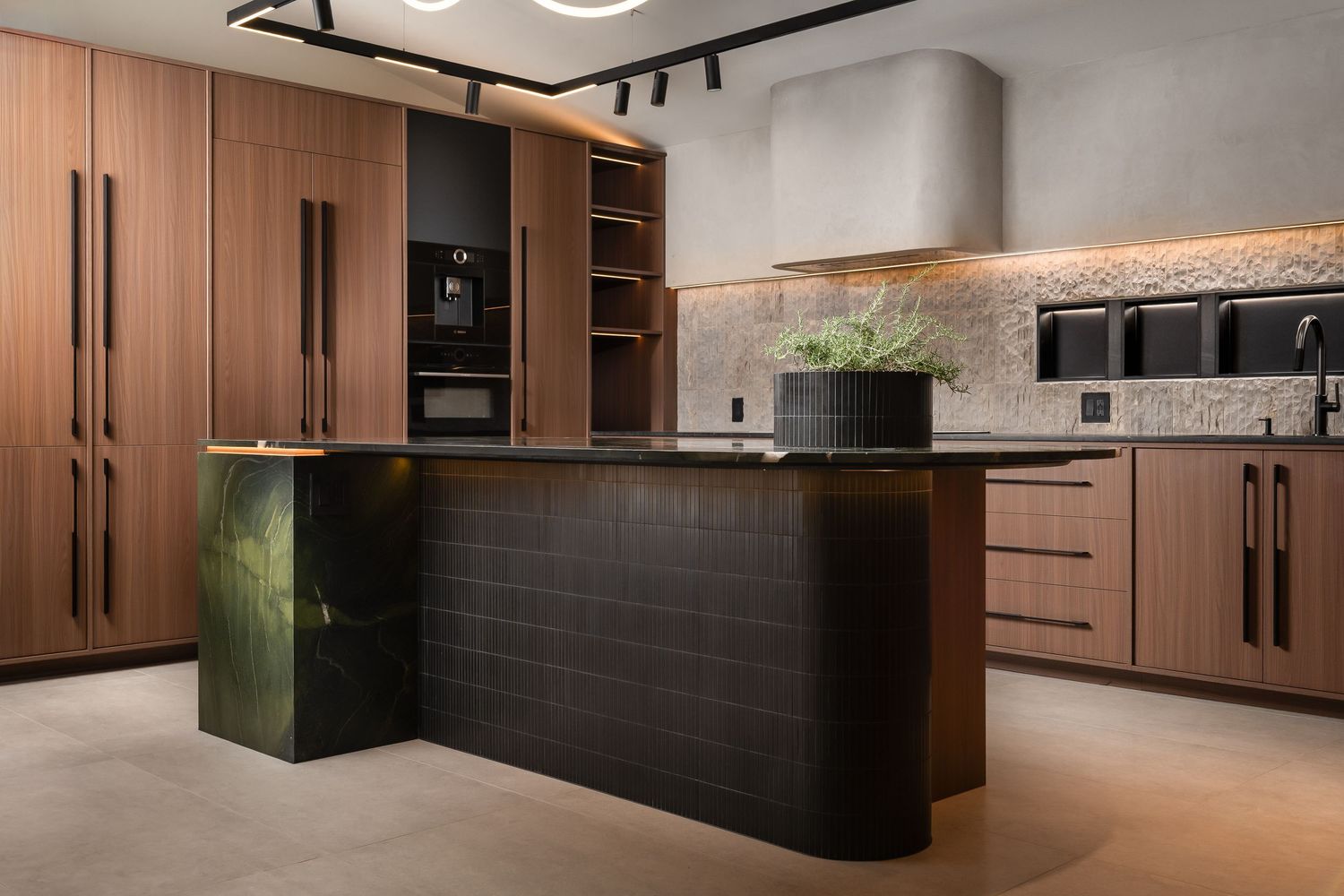 Elegant kitchen featuring wood cabinets, black stone island, and ambient lighting.