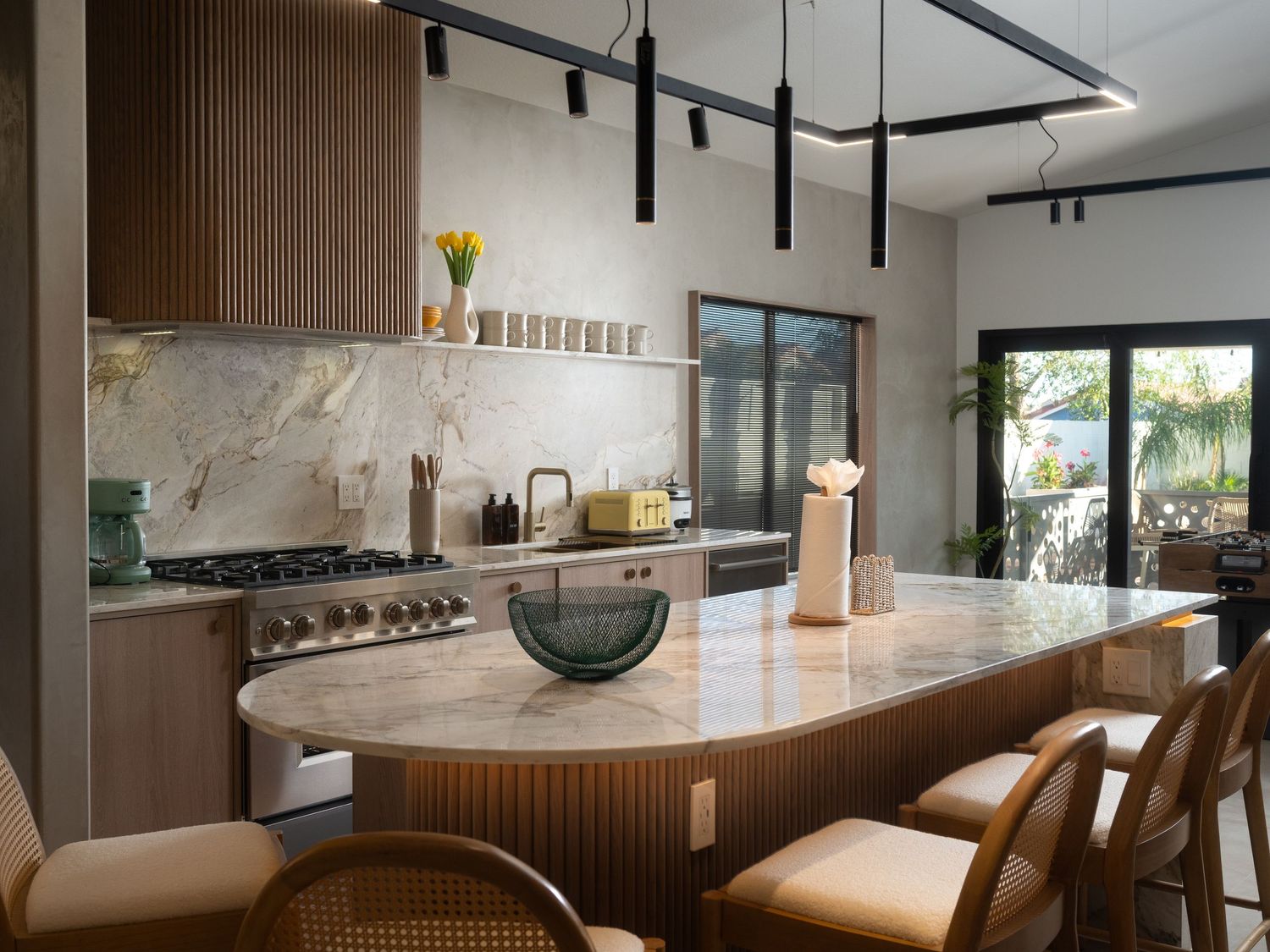 Modern kitchen interior with sleek pendant lights and marble backsplash.