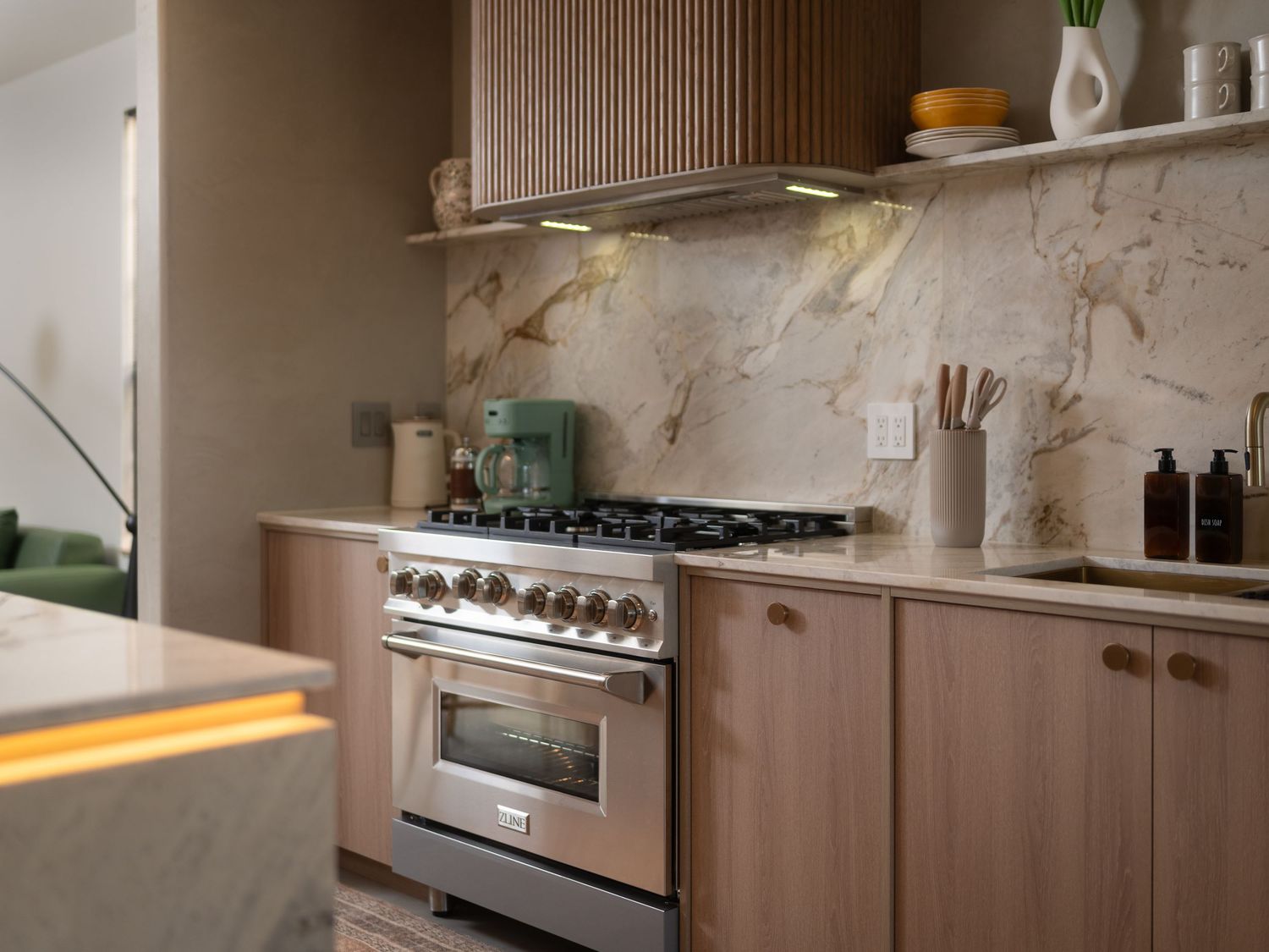 Elegant kitchen with marble backsplash, wood cabinetry, and stainless steel appliances.