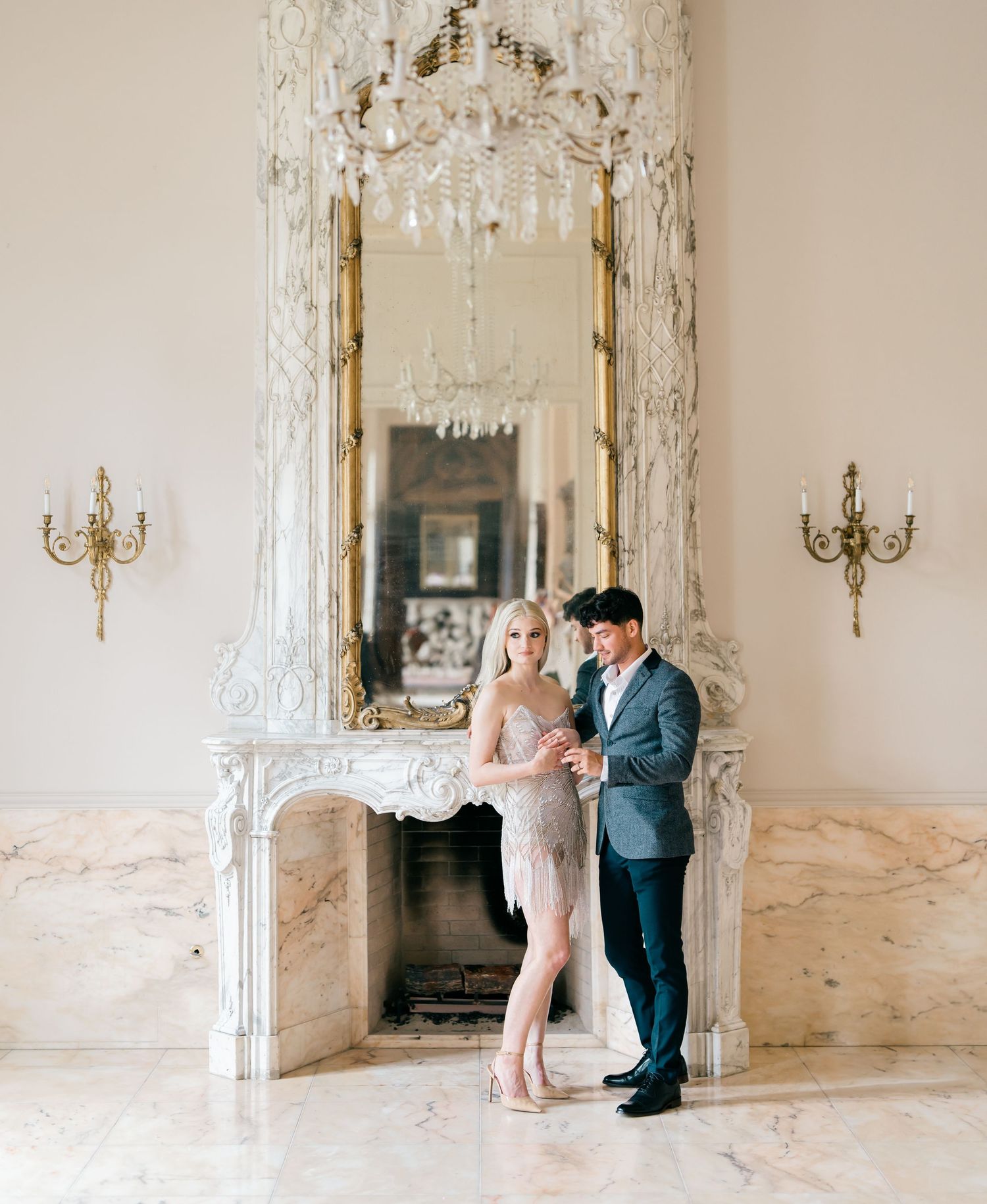Elegant ballroom interior with crystal chandelier and ornate mirrors creating a romantic atmosphere.