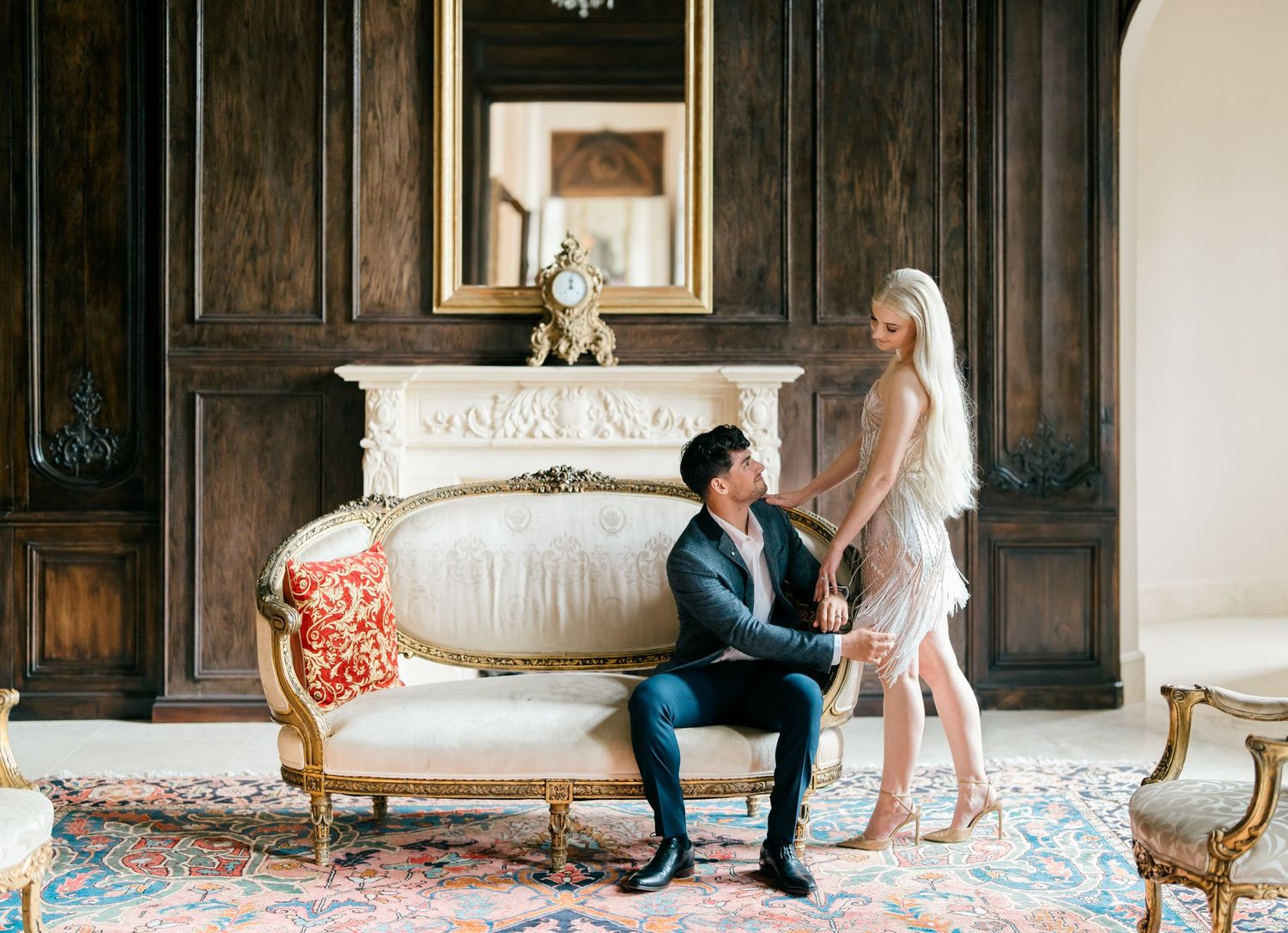 A series of romantic engagement photos showing a couple on an elegant sofa in a grand room with wood paneling.