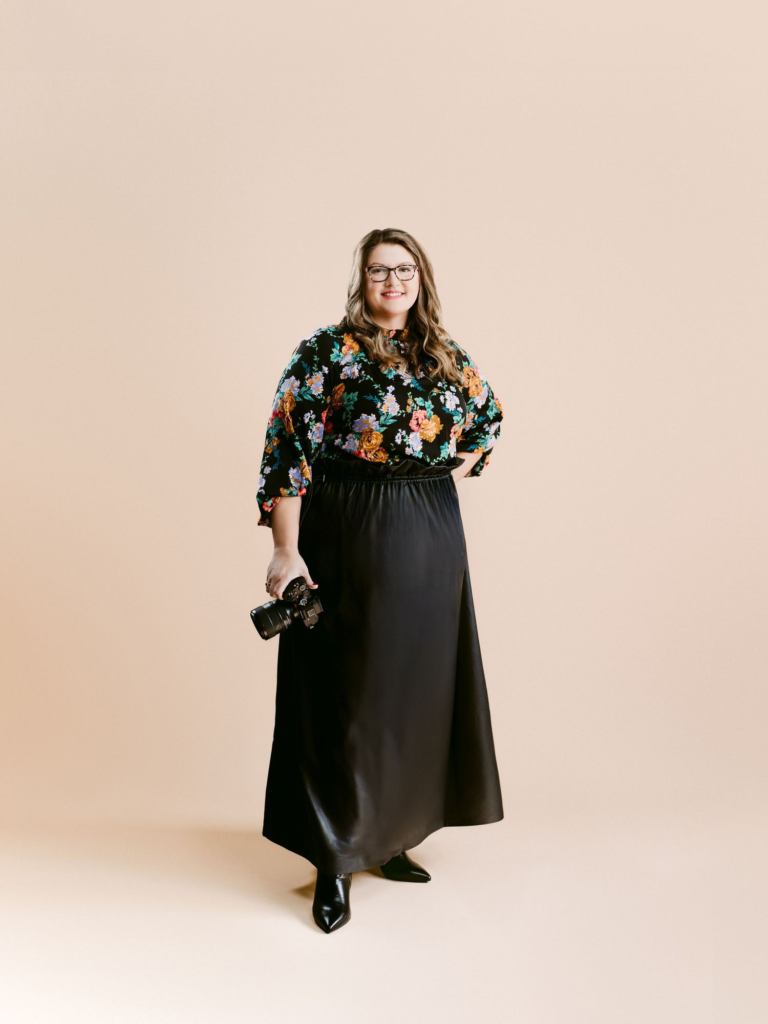 A floral print blouse paired with a flowing black maxi skirt creates an elegant plus-size fashion ensemble.