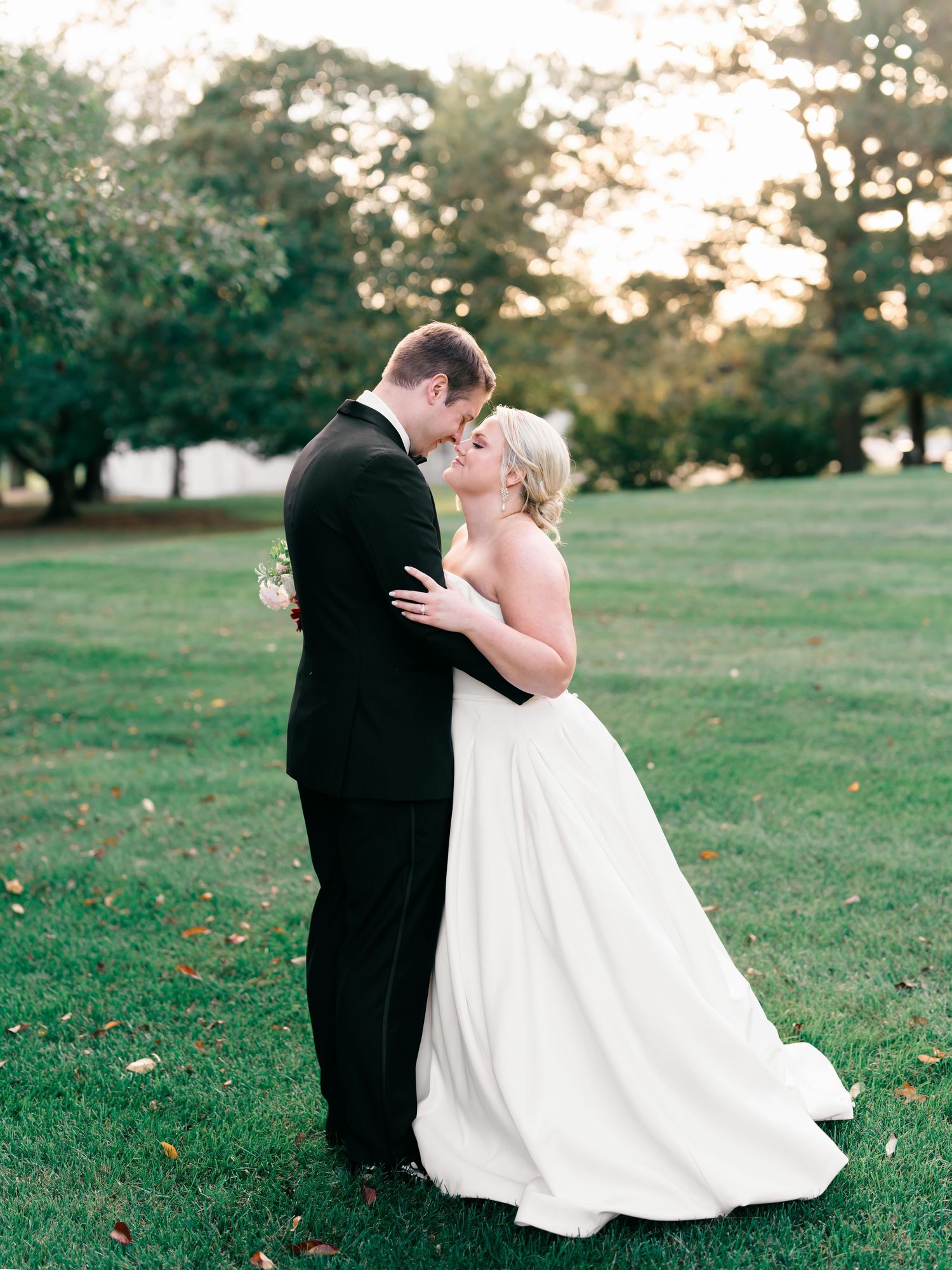 A couple in formal wedding attire shares romantic moments in a series of photos on a grassy lawn at sunset.