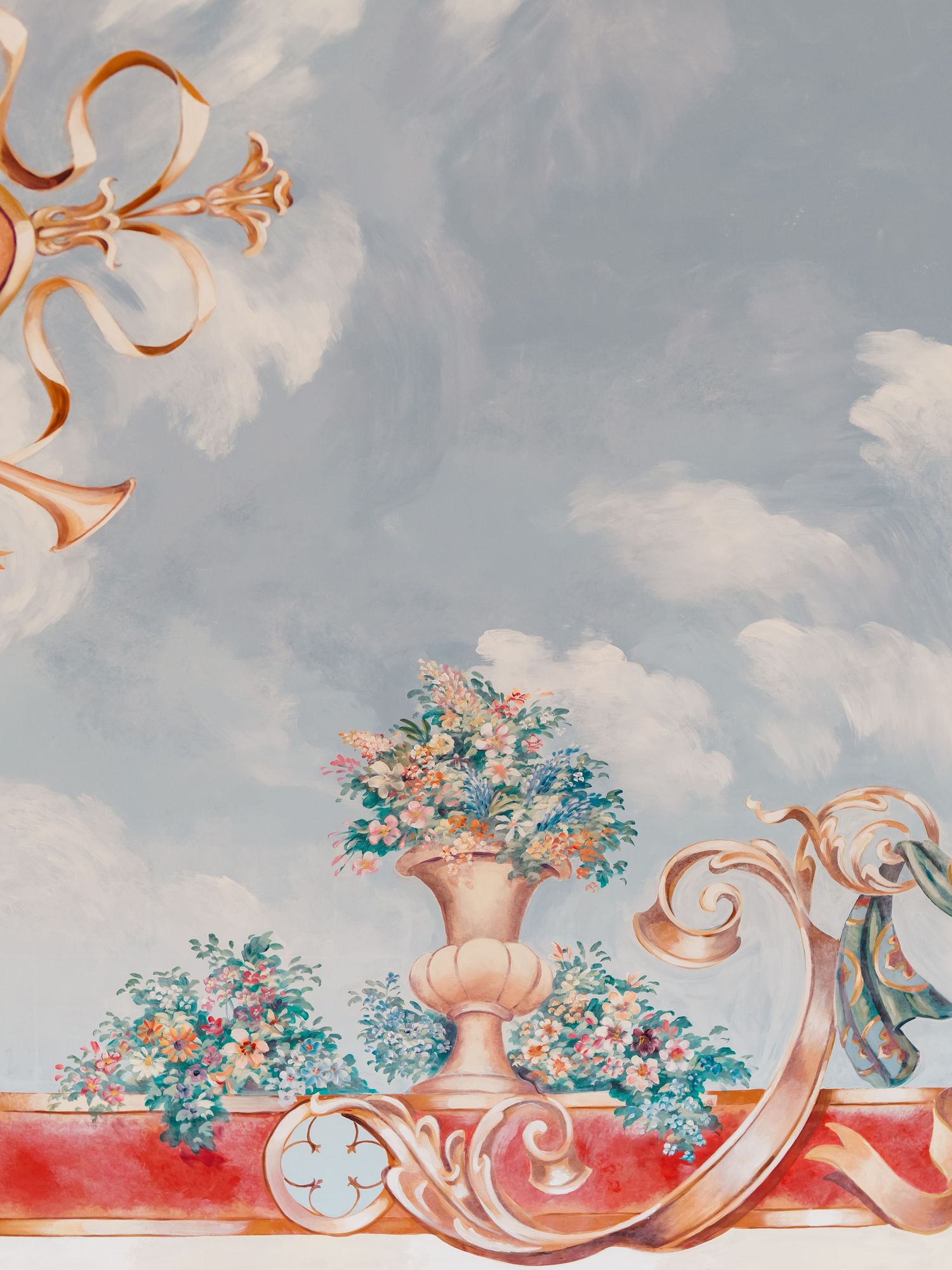 Decorative ceramic vases and ornaments arranged on a shelf against a cloudy sky background in muted pastel tones.
