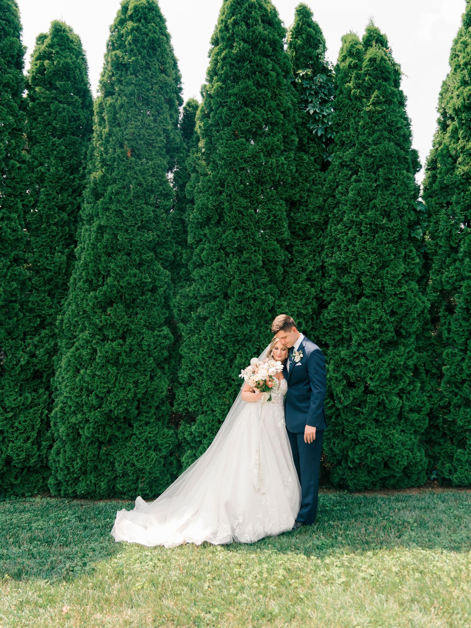 Romantic wedding portrait against tall green cypress trees at The Kentucky Castle.