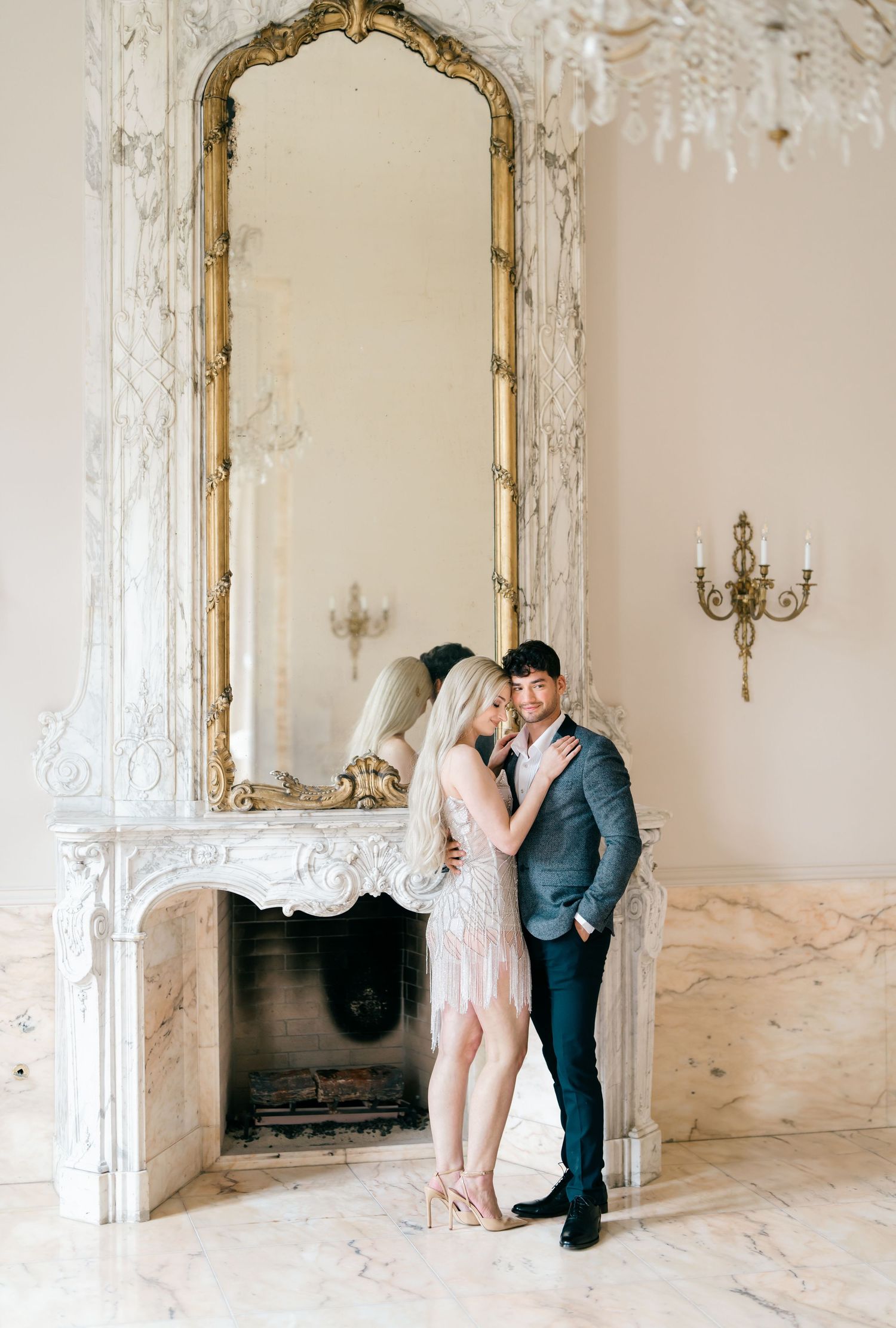 Romantic wedding photo series in an elegant white room with ornate gold mirrors and vintage decor.