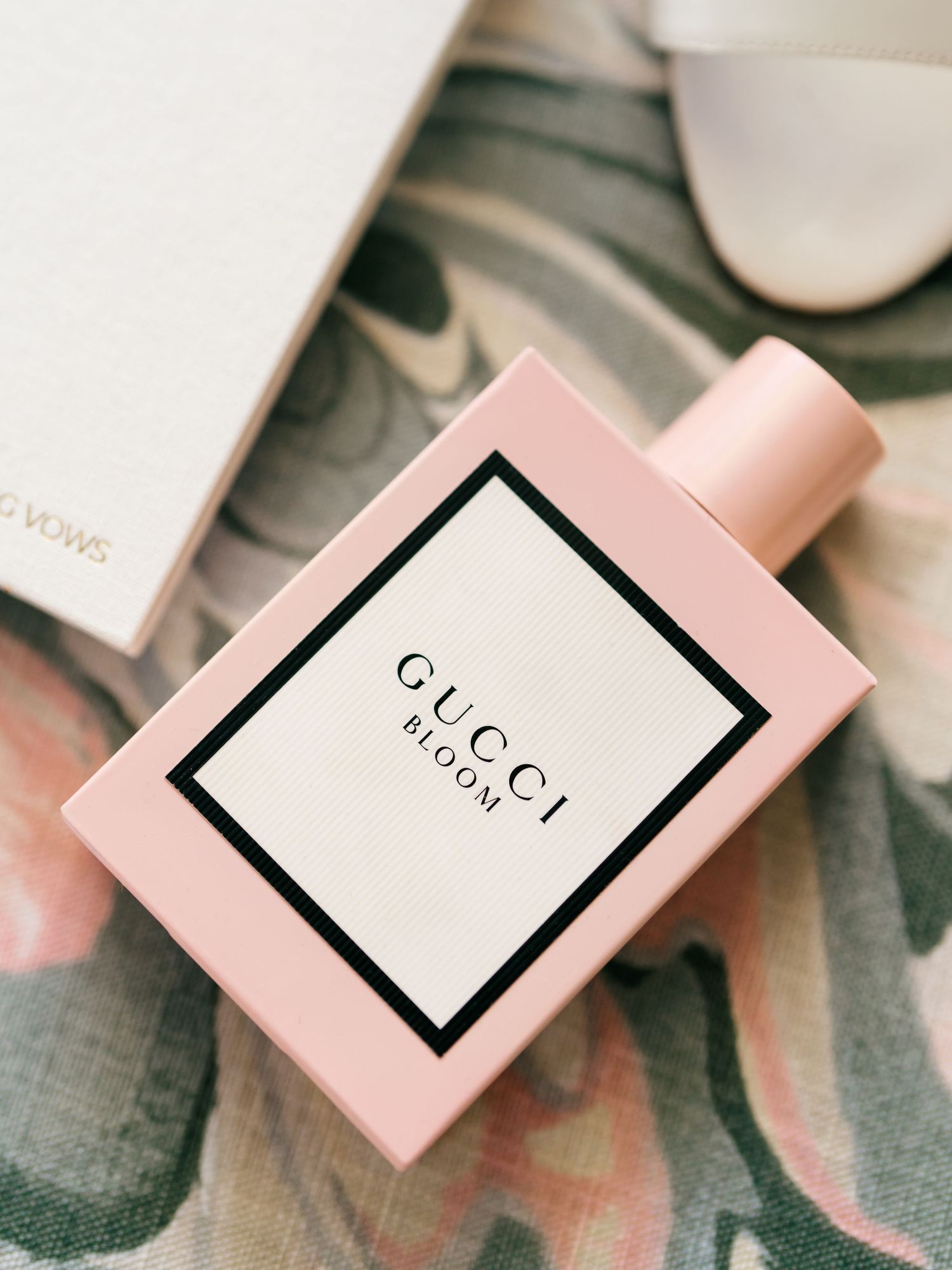 Pink and black luxury perfume boxes arranged on a textured surface.
