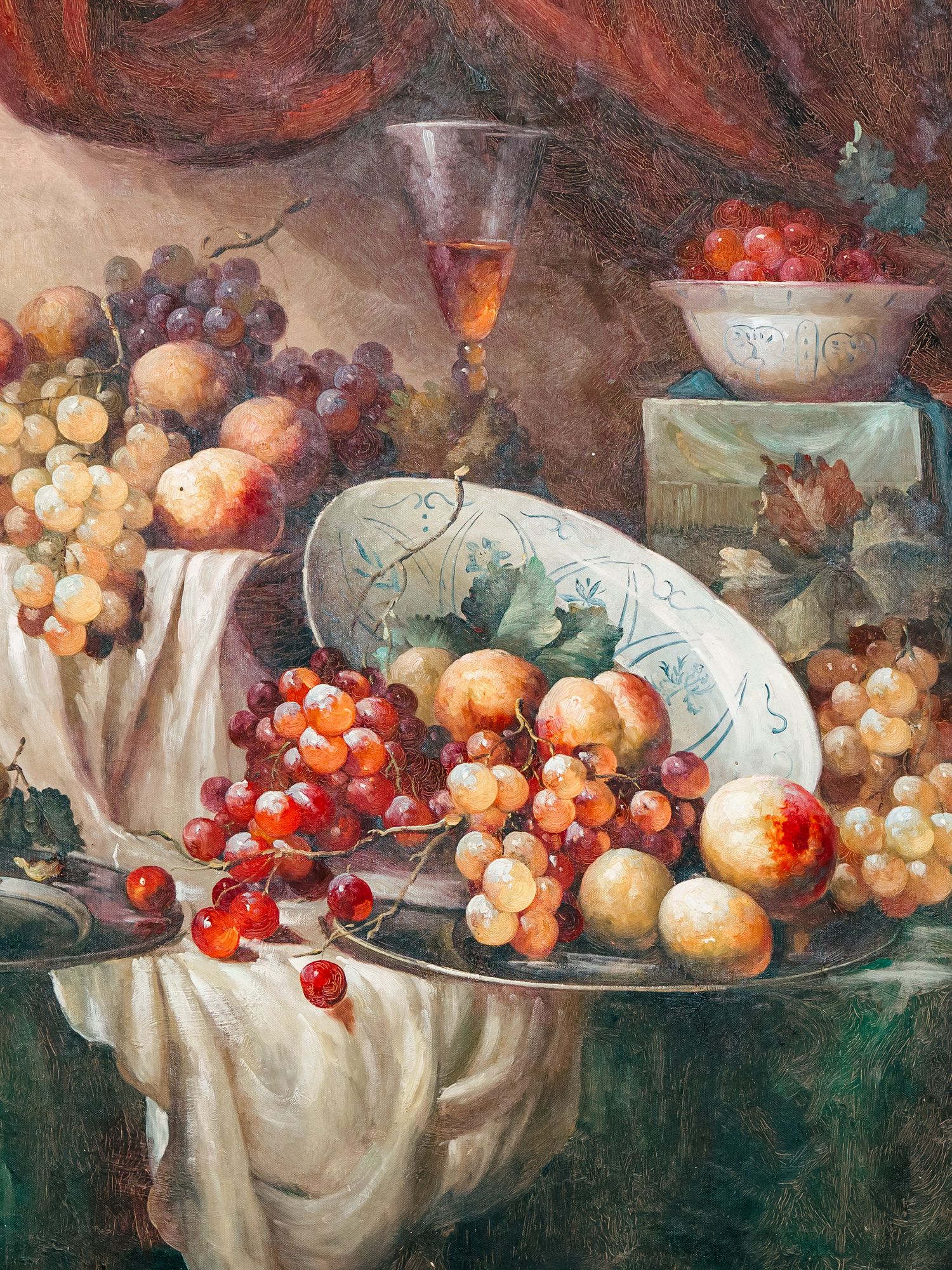 Still life painting of fresh fruits and cherries arranged on white tablecloth with ornate porcelain dishes.