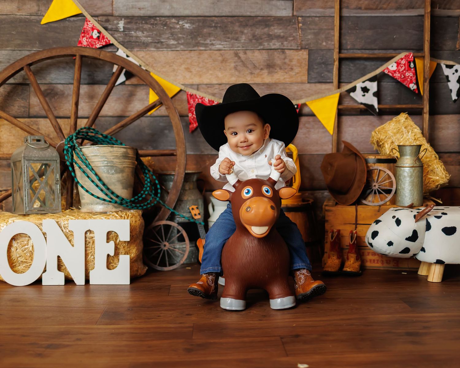 Forest animal themed birthday party decor with stuffed toys and rustic woodland elements on wooden shelf display.
