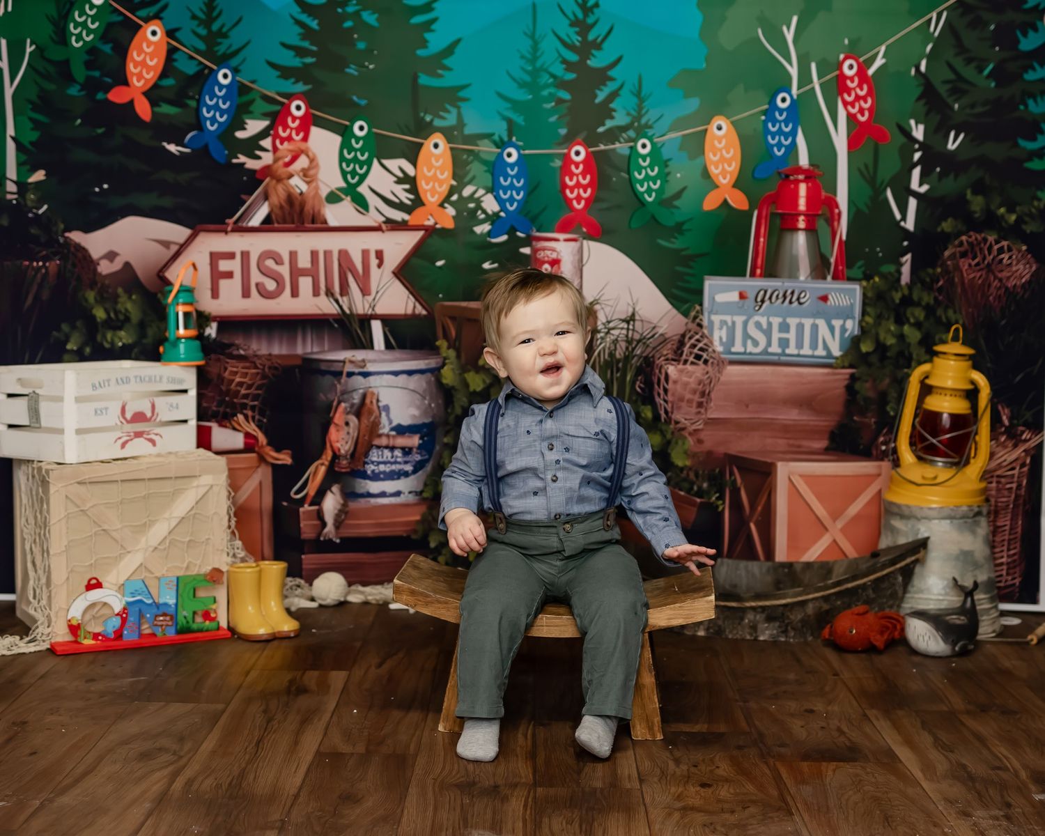 A fishing-themed set with rustic decorations including lanterns, tackle boxes and colorful banners against a woodsy backdrop.