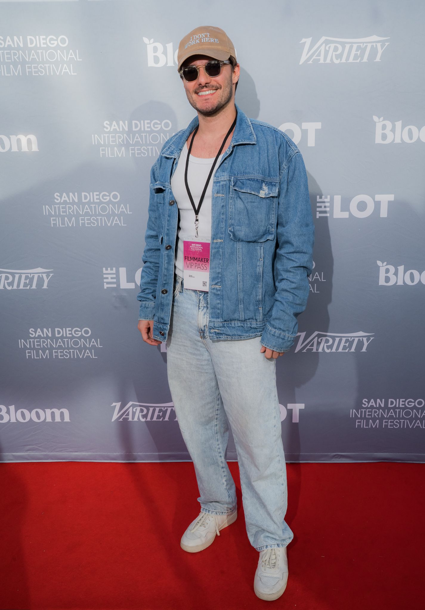 Man in denim jacket and cap poses on red carpet at San Diego International Film Festival with Variety backdrop.
