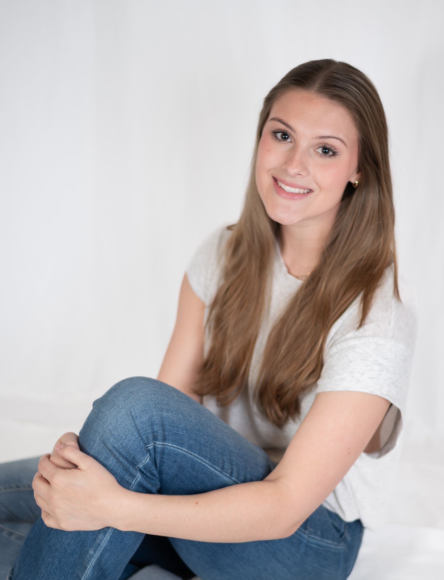 Person in white shirt and jeans poses against white background during a branding session in Birmingham, AL.