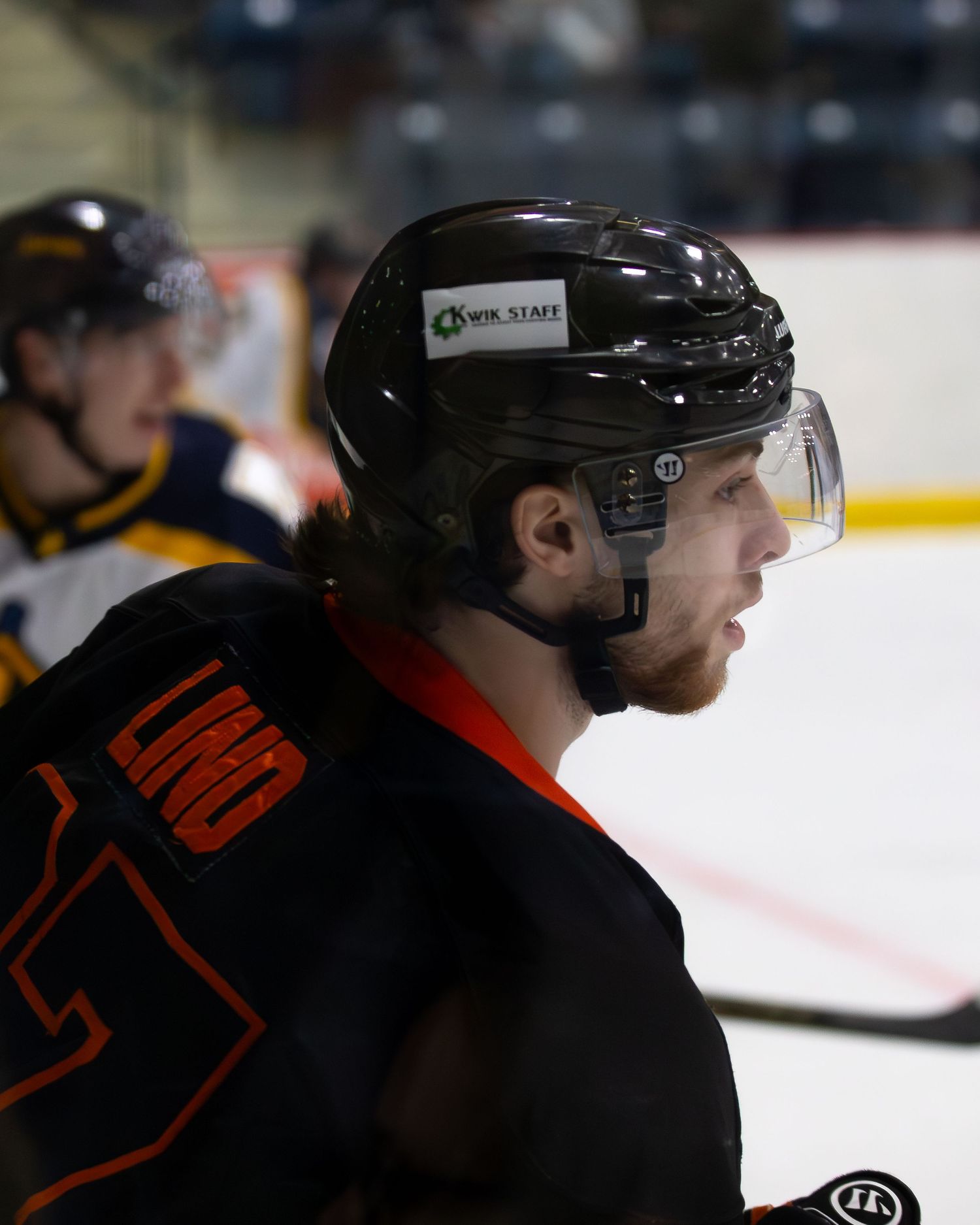 Hockey player in black helmet and Scarecrows jersey focuses during game on ice.