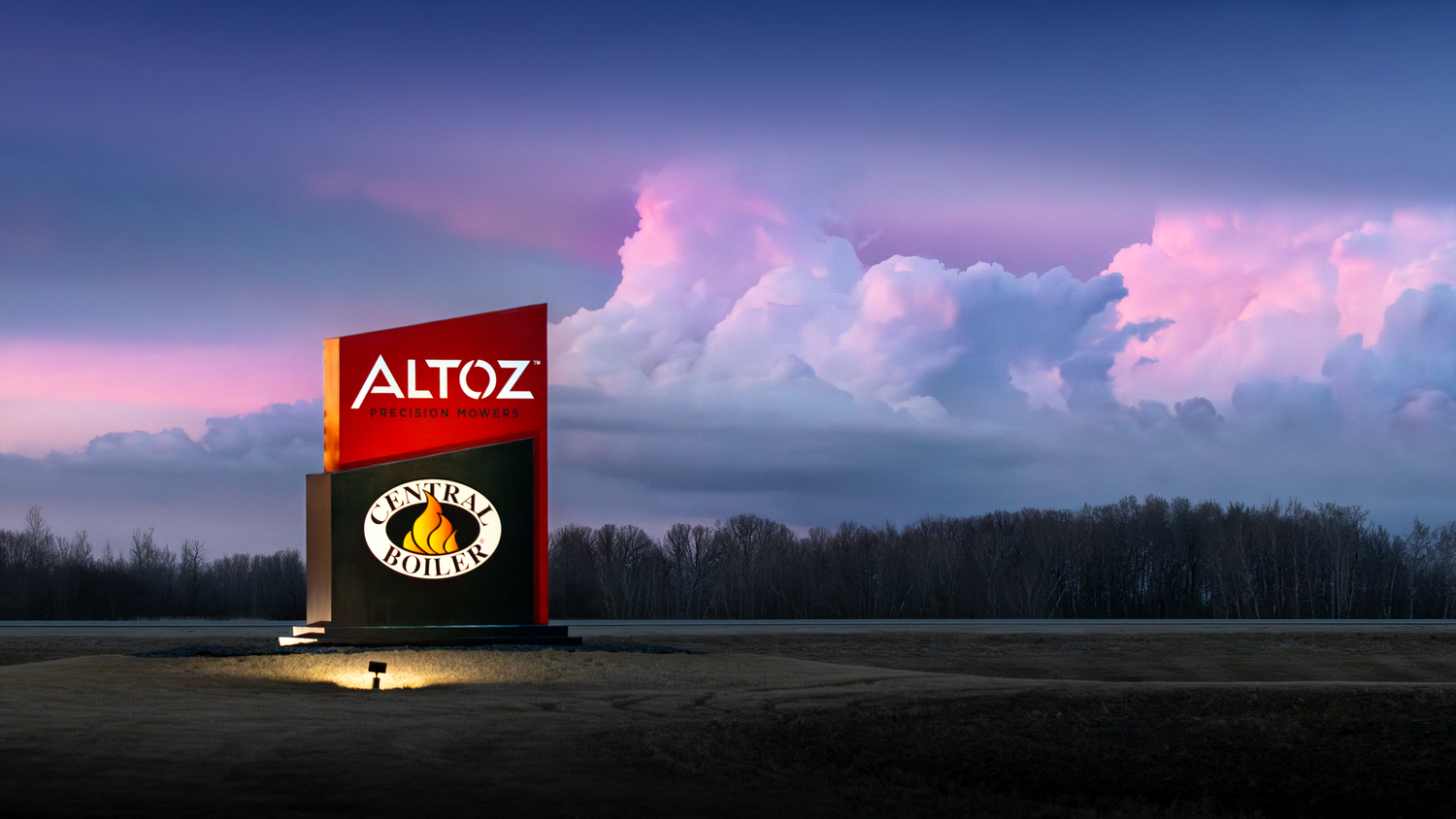 Illuminated Altoz brand sign glows against dramatic purple and pink cloudy sunset sky.