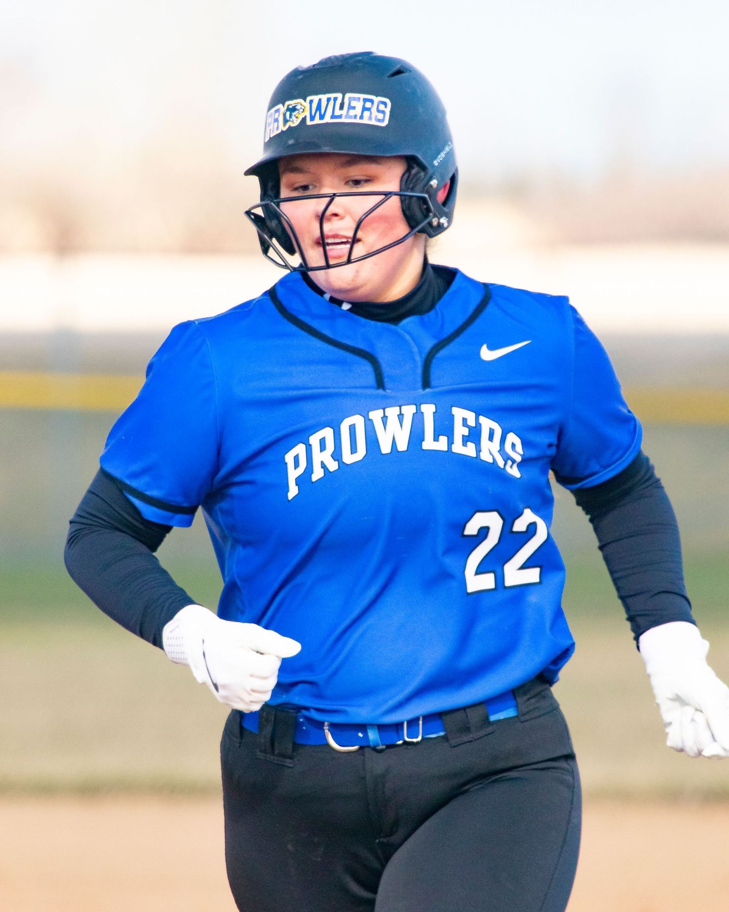 Softball player #22 in blue Prowlers uniform and helmet runs the bases during a game.