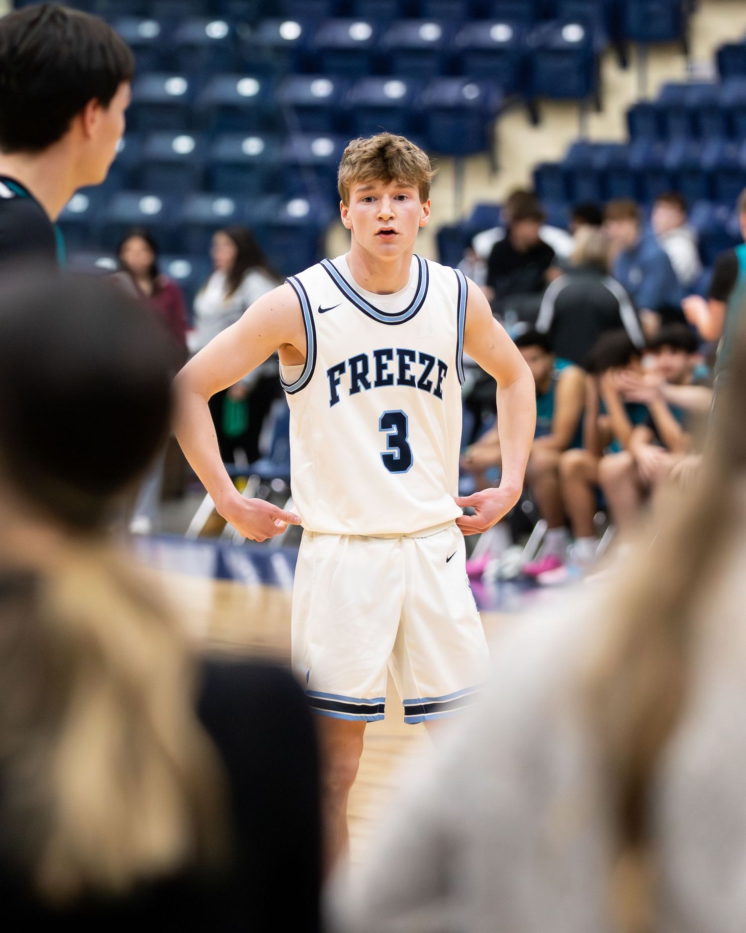 Basketball player number 3 in Freeze jersey stands on court during game.