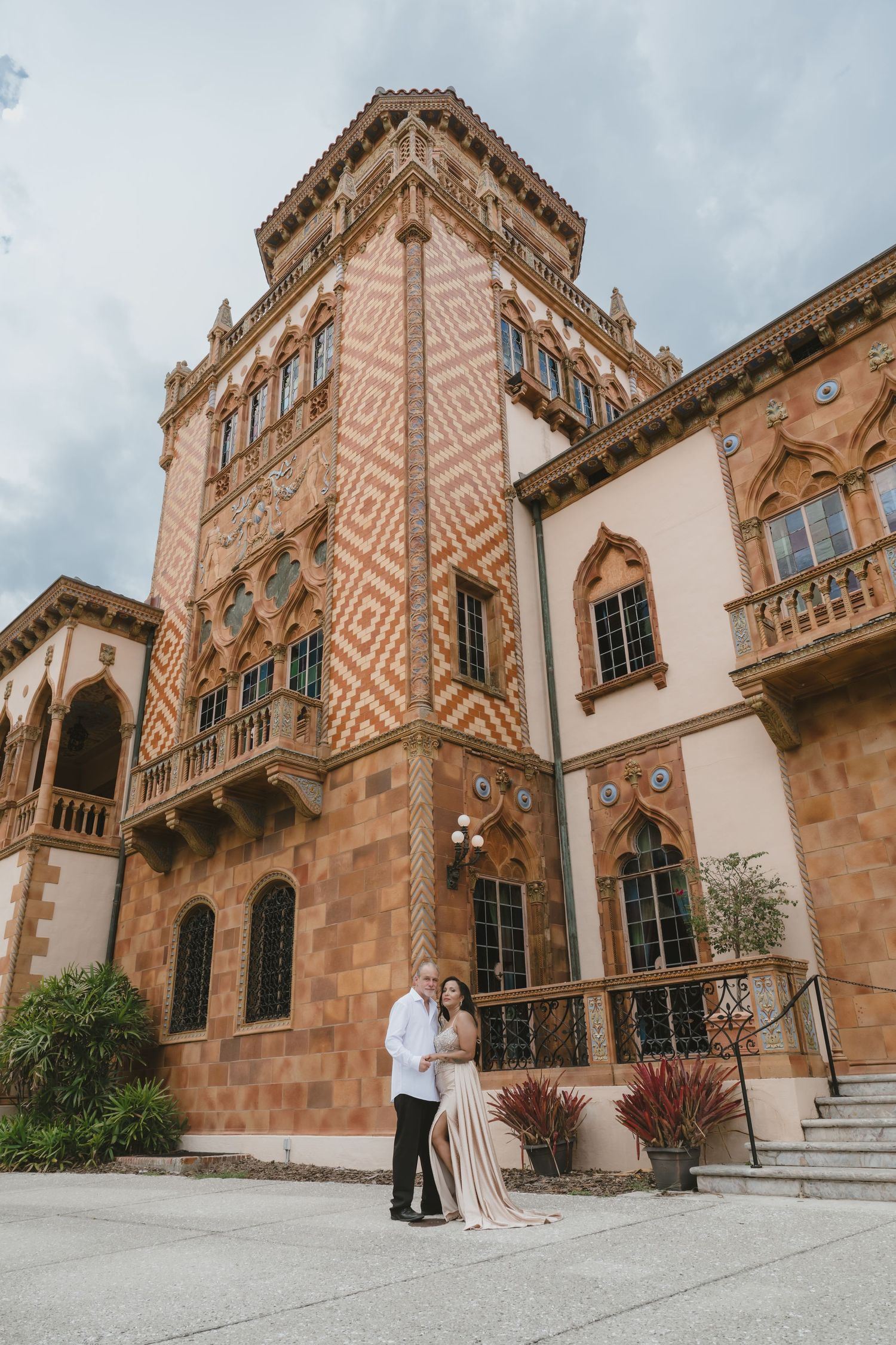 Couple embracing in front of ornate Venetian Gothic tower at Ringling Museum, Sarasota, Florida.