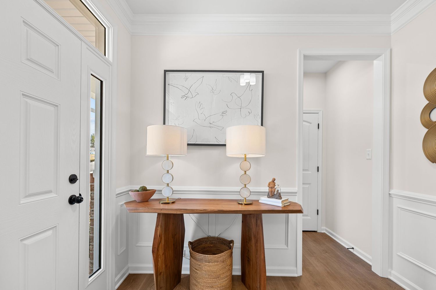 Minimalist entryway featuring wooden console table, twin table lamps, and abstract wall art.