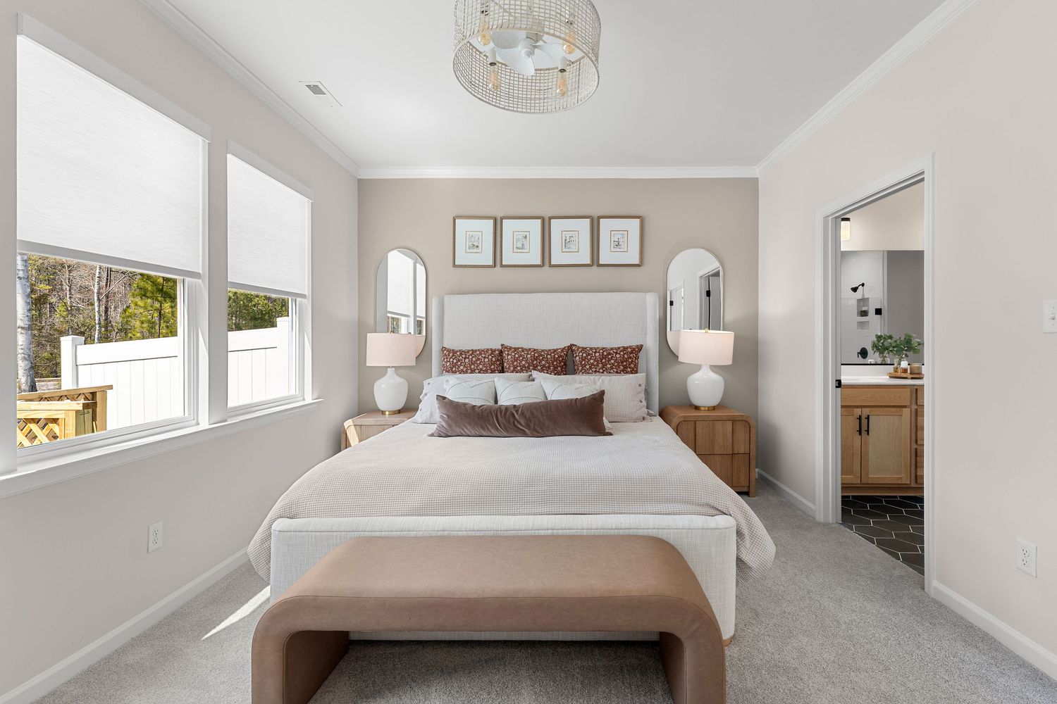 Minimalist bedroom design with white walls, neutral bedding, and abundant natural light.