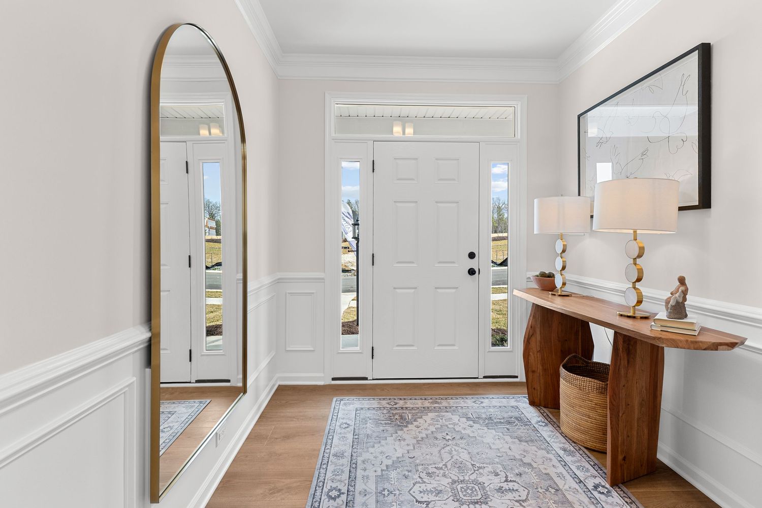 Welcoming foyer with full-length mirror, wooden console table, and patterned area rug.