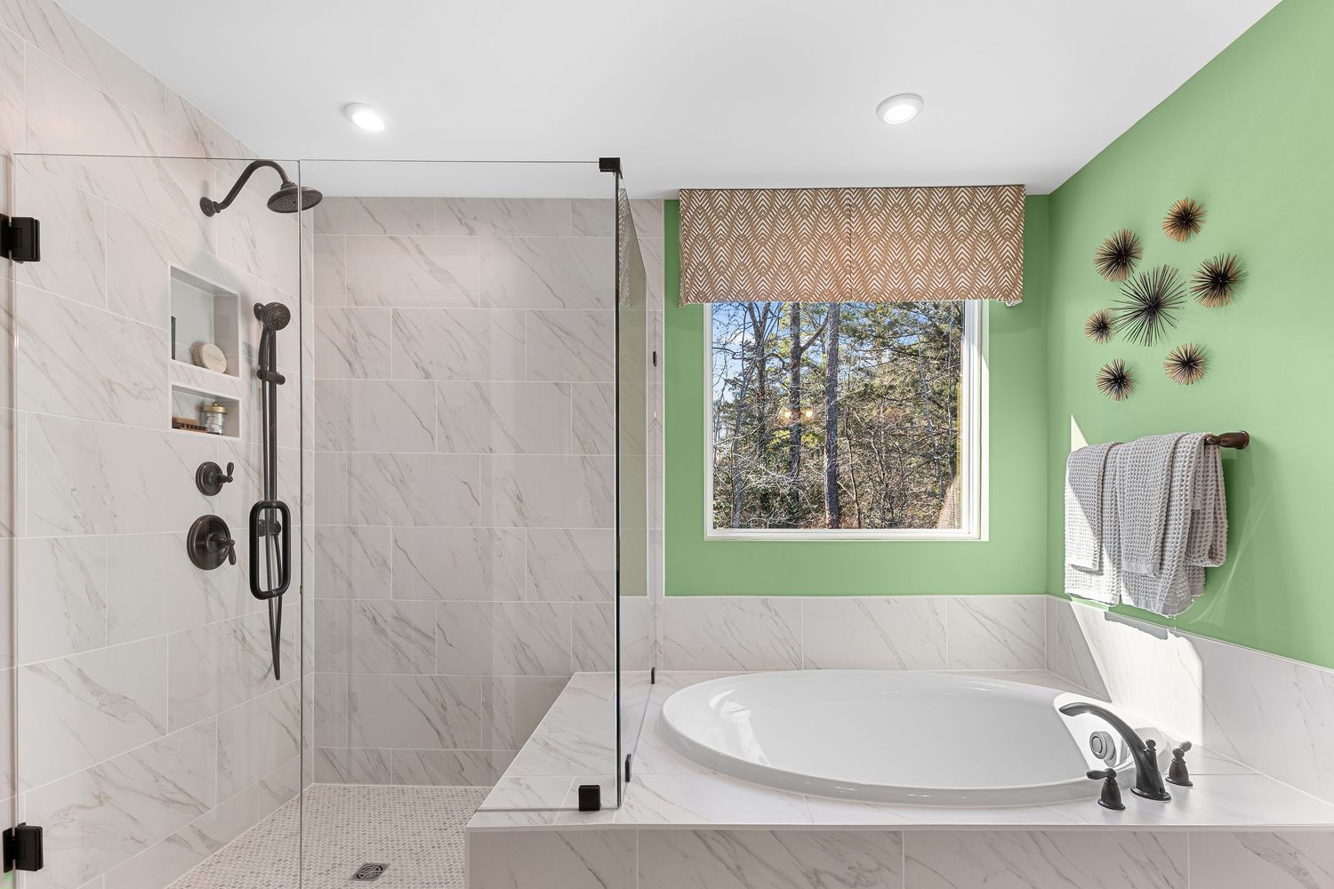 Modern bathroom interior with mint green accent wall, white marble tiles, and sleek fixtures arranged in panoramic view.