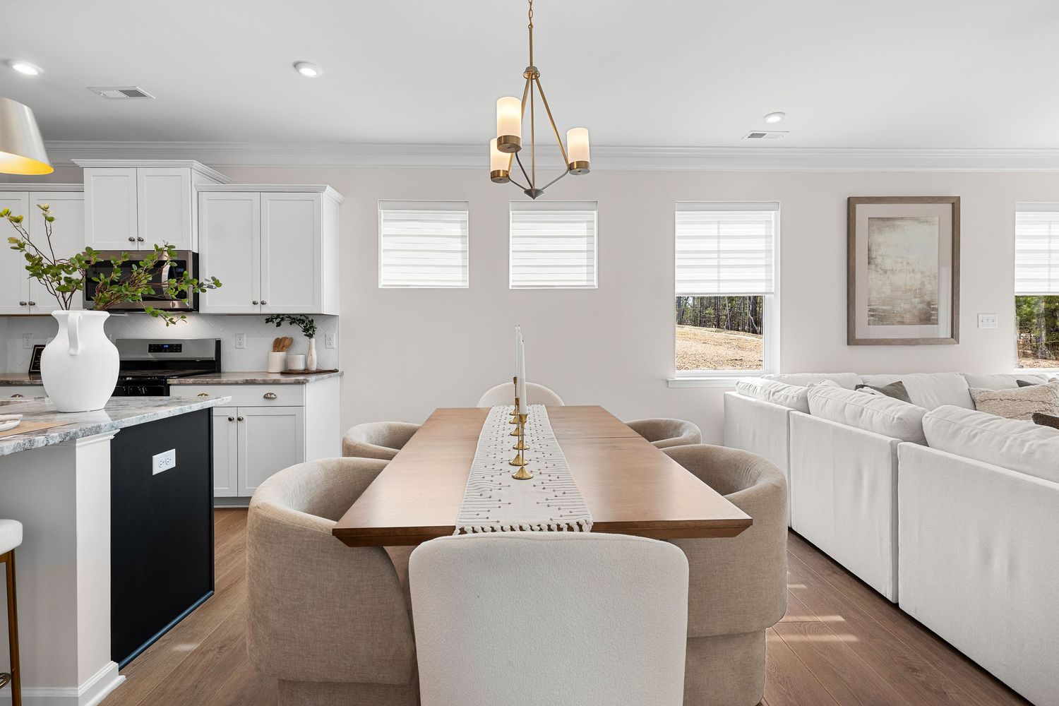 Modern white interior featuring recessed lighting, hardwood floors, and elegant dining area.