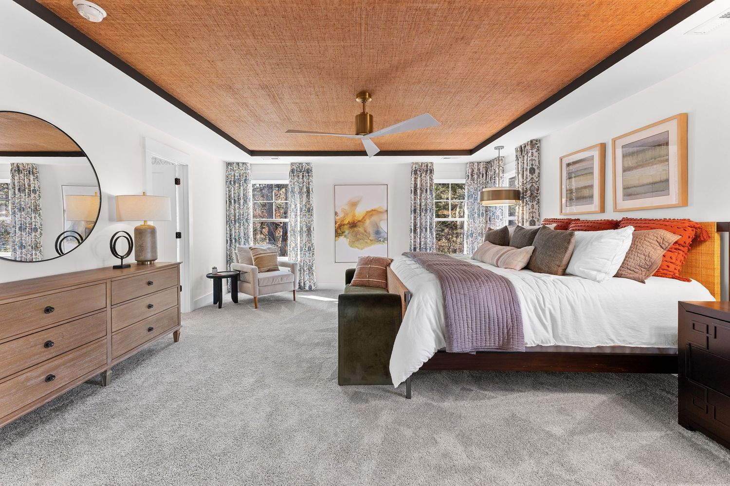 Modern bedroom with exposed wood beam ceiling, white bedding, and large windows showcasing mountain views.