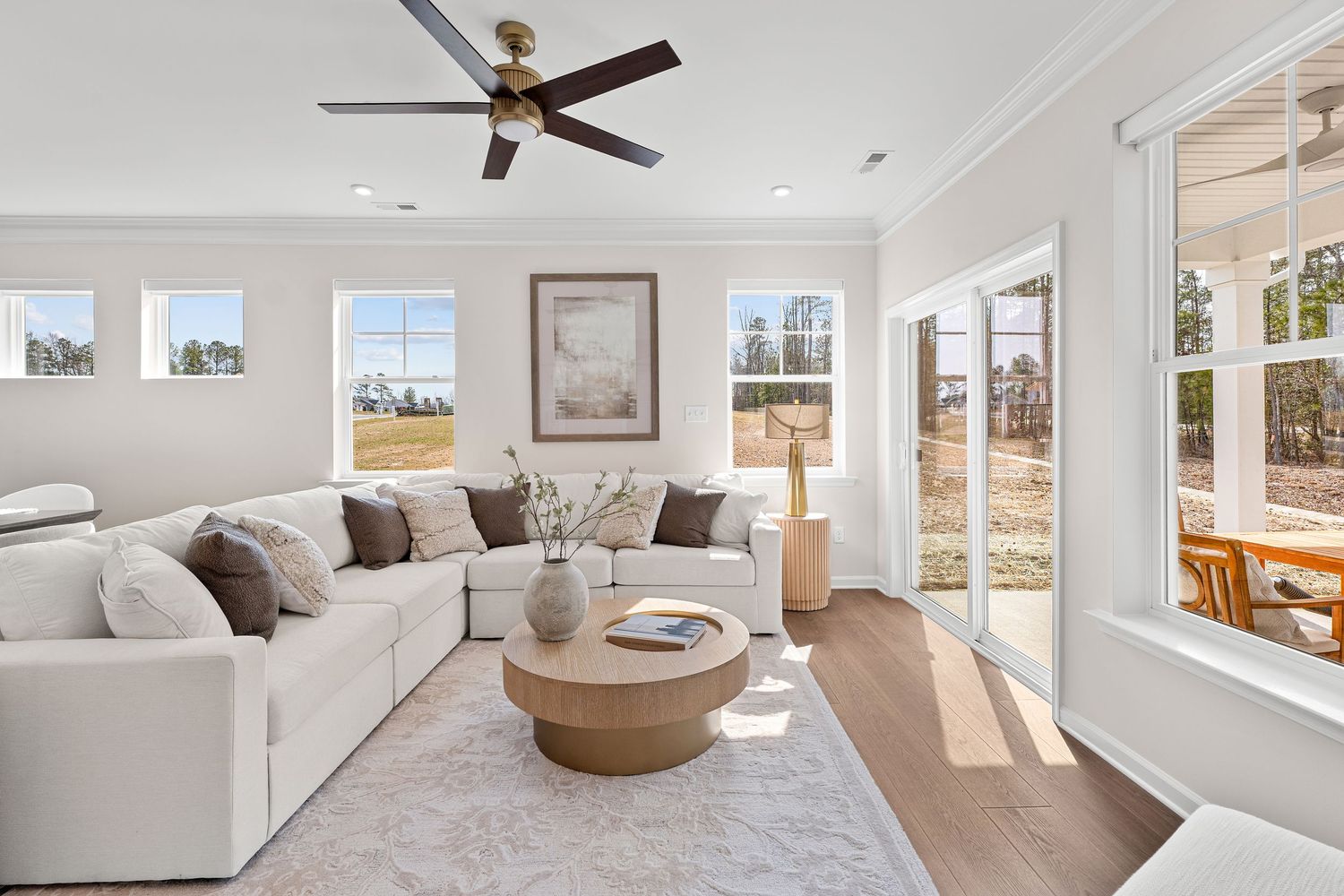 Spacious bedroom with ceiling fan, natural lighting, and neutral furnishings.