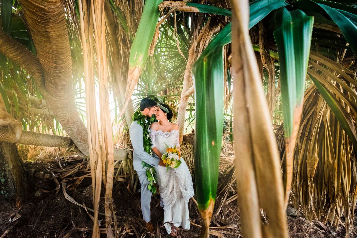 Wedding photos captured among tropical palm trees and greenery in Hilo, Big Island of Hawaii.