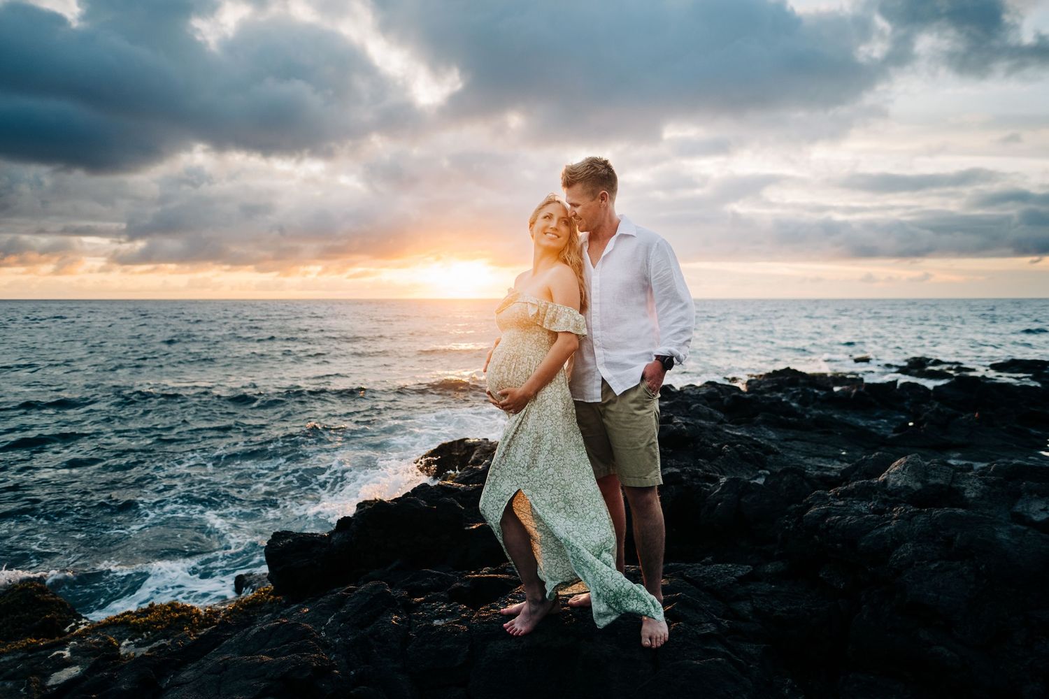 Dramatic coastal photo shoot at sunset with rocky cliffs and crashing waves in Hawaii at Kukio Beach, Big Island of Hawaii.