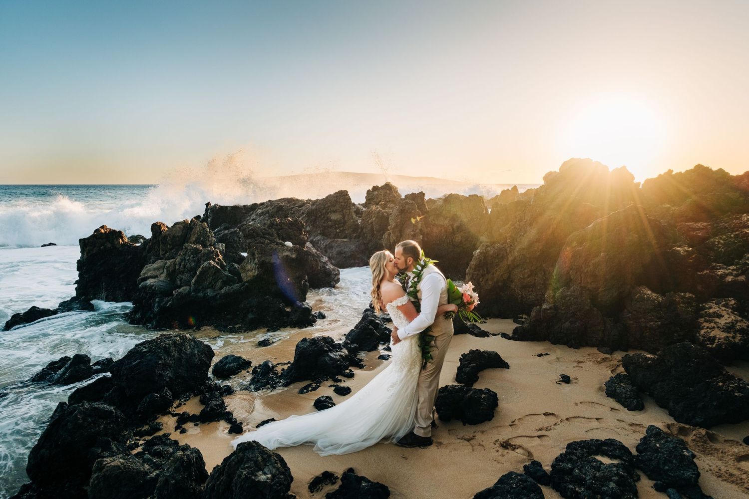 Dramatic sunset wedding photos on volcanic rocks by the ocean on Maui, Hawaii.