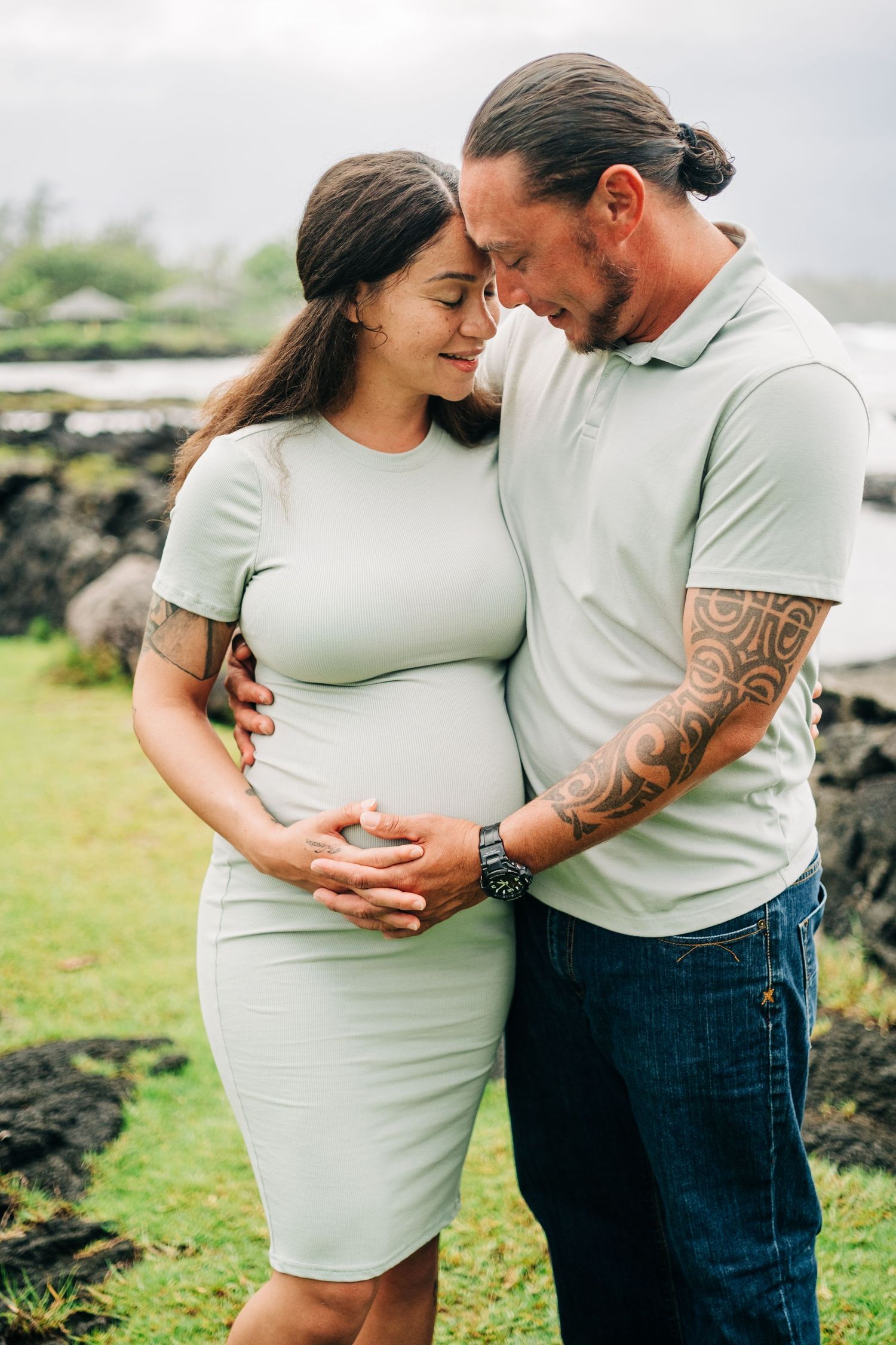 Intimate maternity photos of couple in matching light colored outfits in Hilo, Big Island of Hawaii.