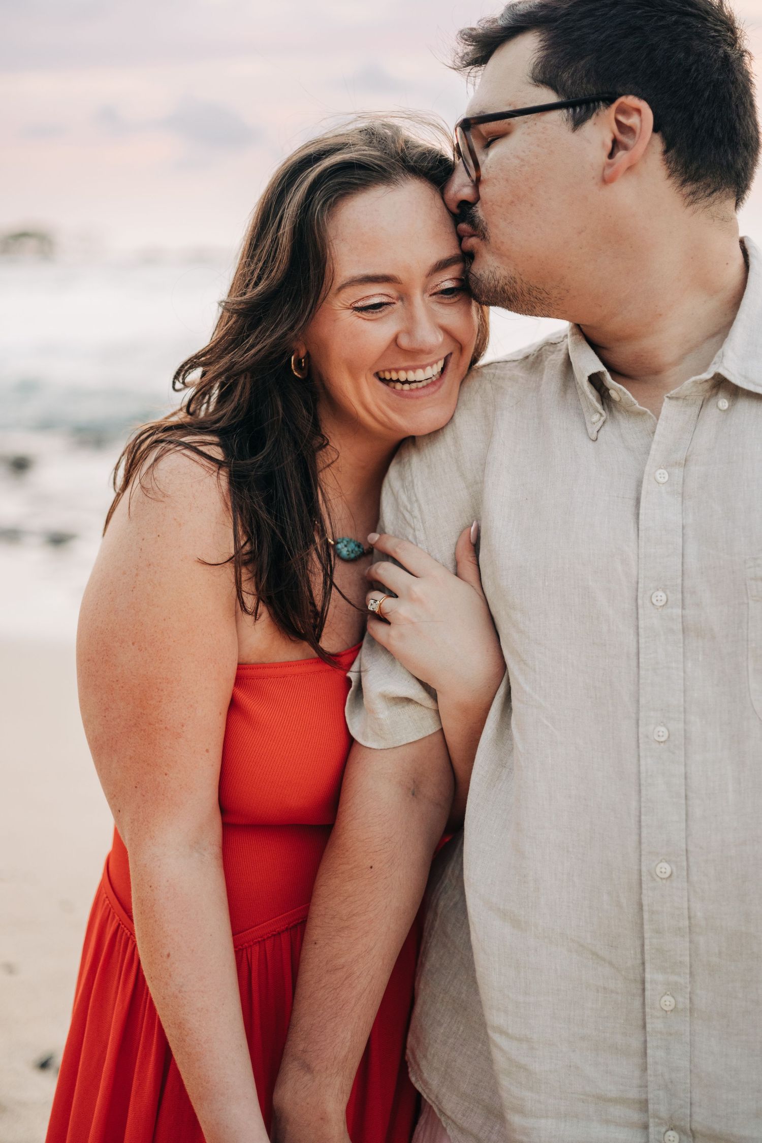 Intimate beach portraits showing joyful laughter and tender moments at sunset on Kukio Beach, Kona, Big Island of Hawaii.