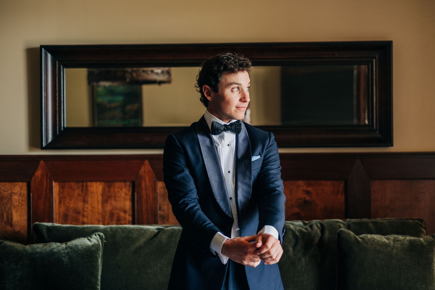 Classic groom preparation photos in formal attire within elegant indoor setting.