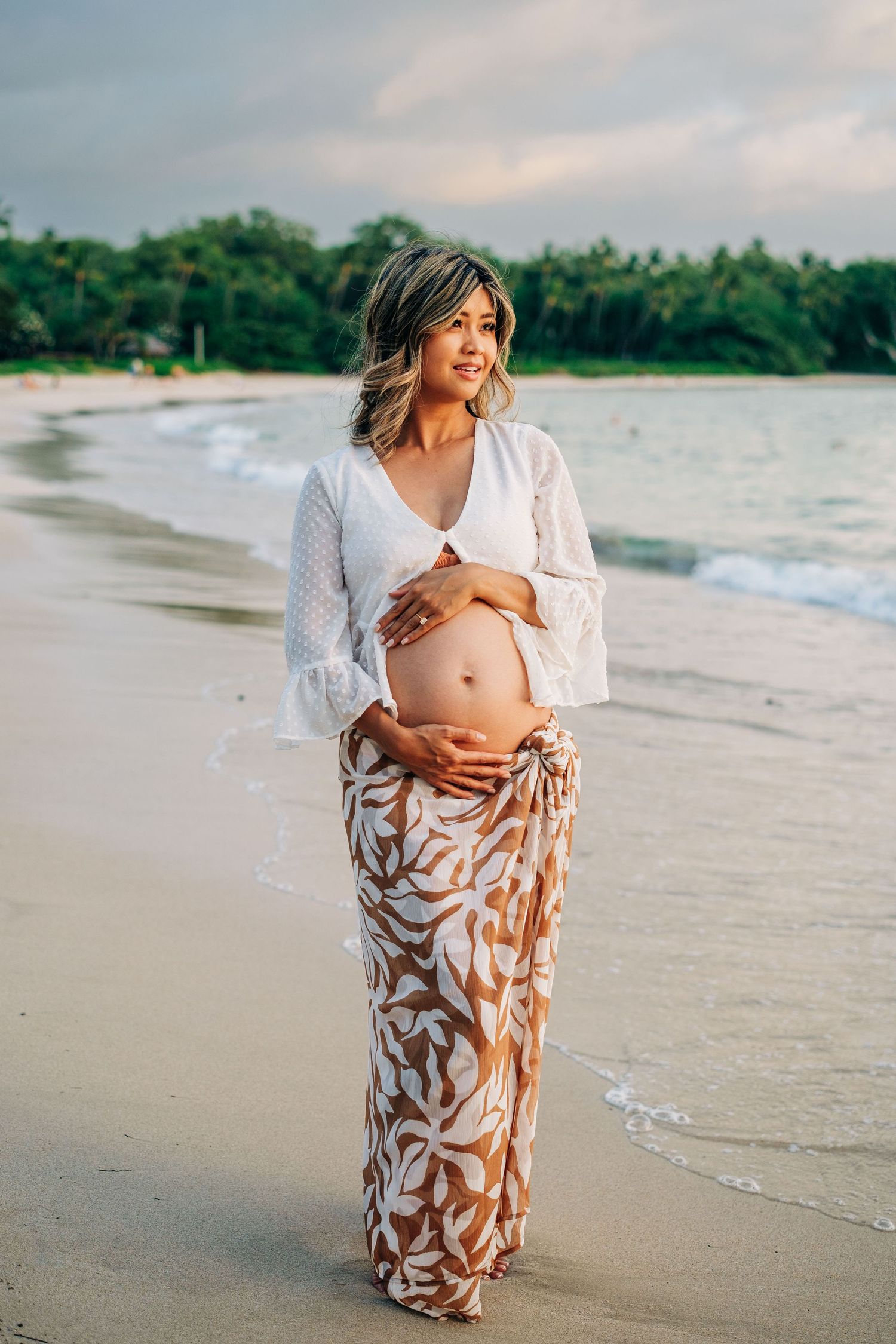 Maternity photo session on tropical beach with flowing fabric wrap at Mauna Kea Beach, Big Island Hawaii.