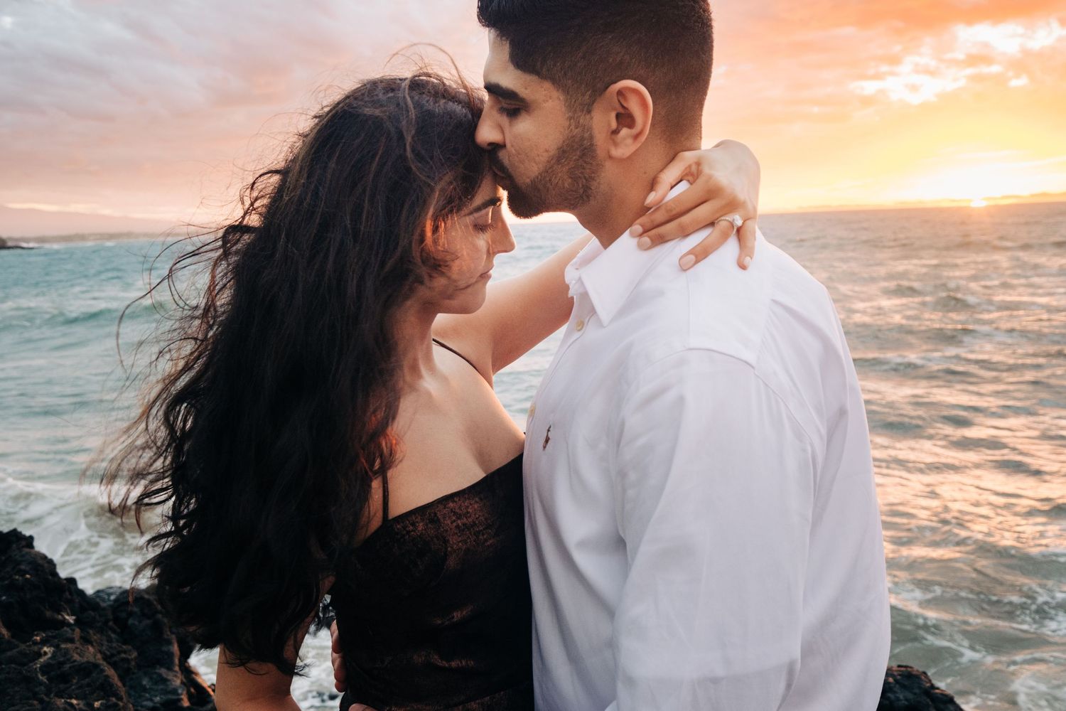 Romantic beach photoshoot at sunset with waves crashing in the background at Hapuna Beach Resort.