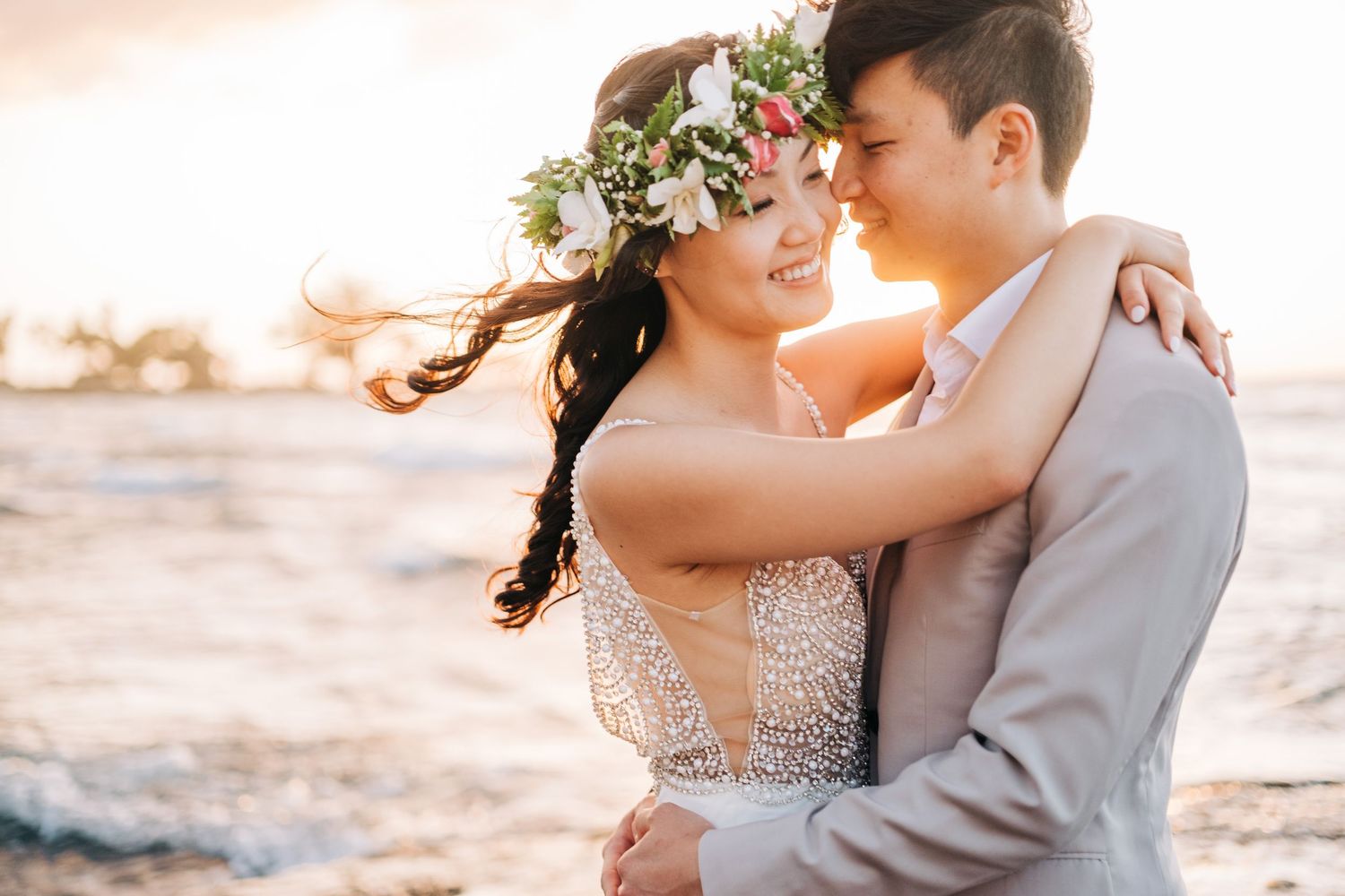 Elegant wedding couple embraces during their sunset beach photo session in Hawaii on Kukio Beach, Big Island of Hawaii.