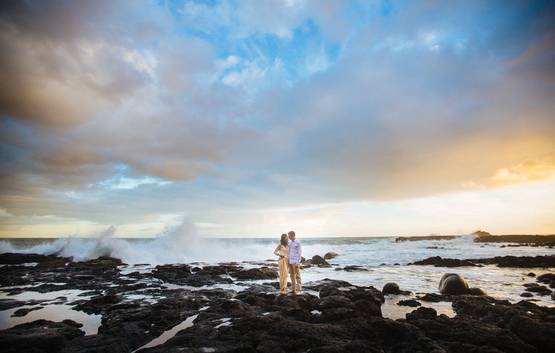 Dramatic sunset over a rocky Hawaiian beach coastline with colorful clouds at Hilo, Big Island of Hawaii.