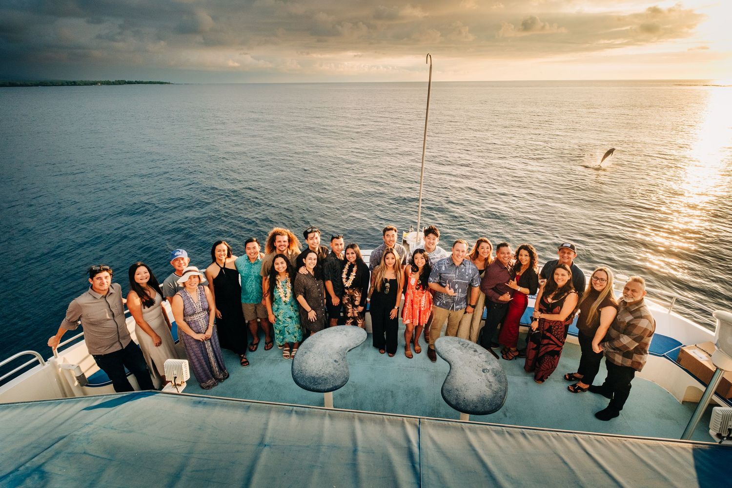 People gathered on a boat deck watching a beautiful ocean sunset in Kona, Big Island of Hawaii.
