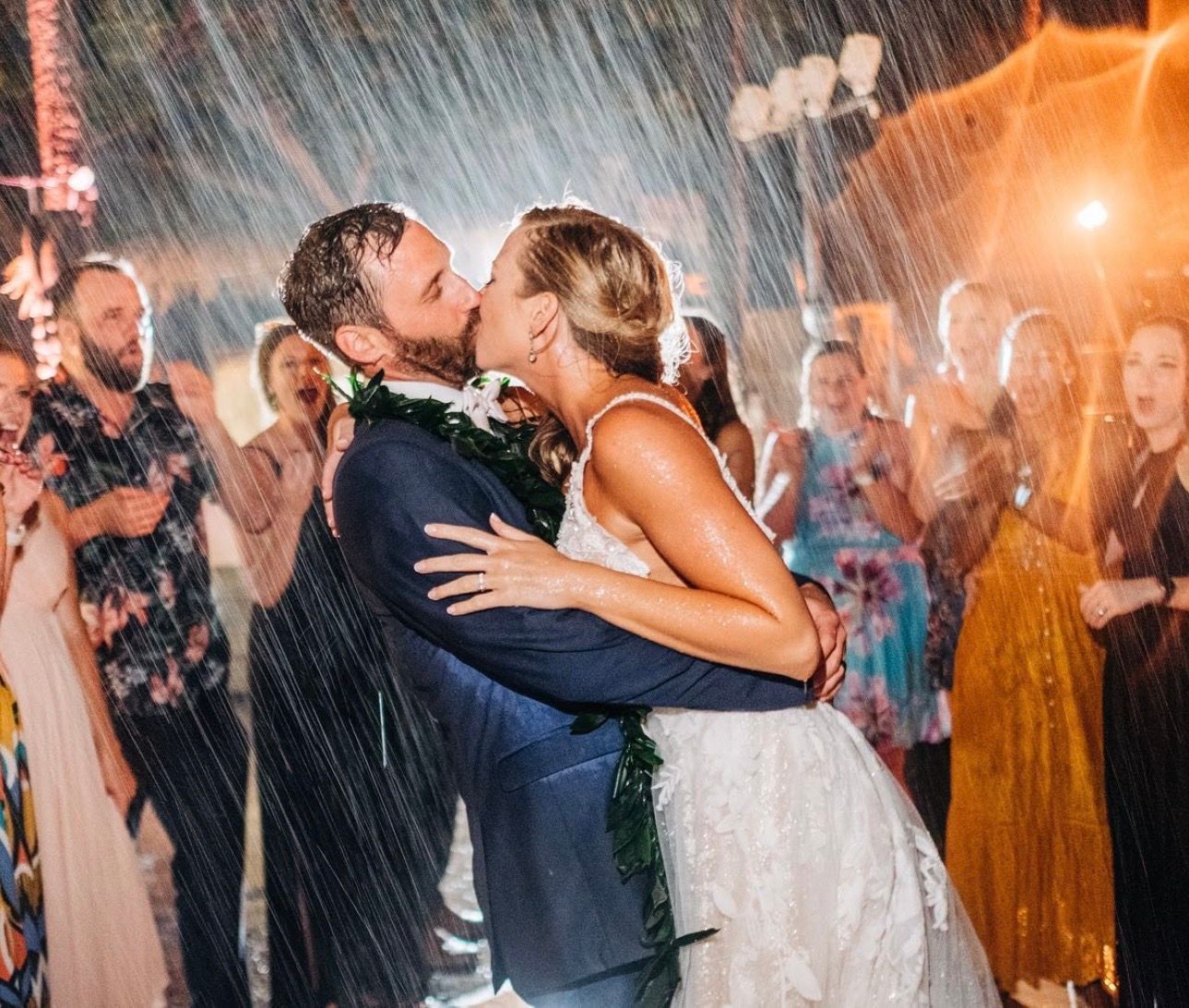 Kona wedding couple sharing a romantic dance in the rain surrounded by guests.