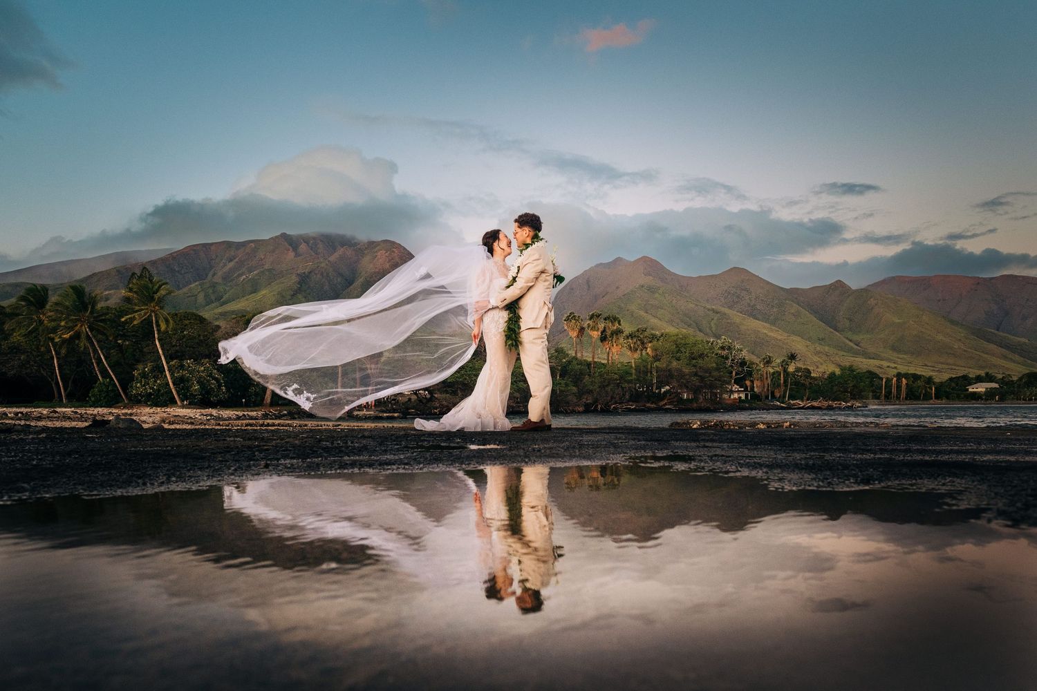 Panoramic wedding portraits with mountain and lake reflections at sunset in a scenic landscape at Olowalu, Maui.