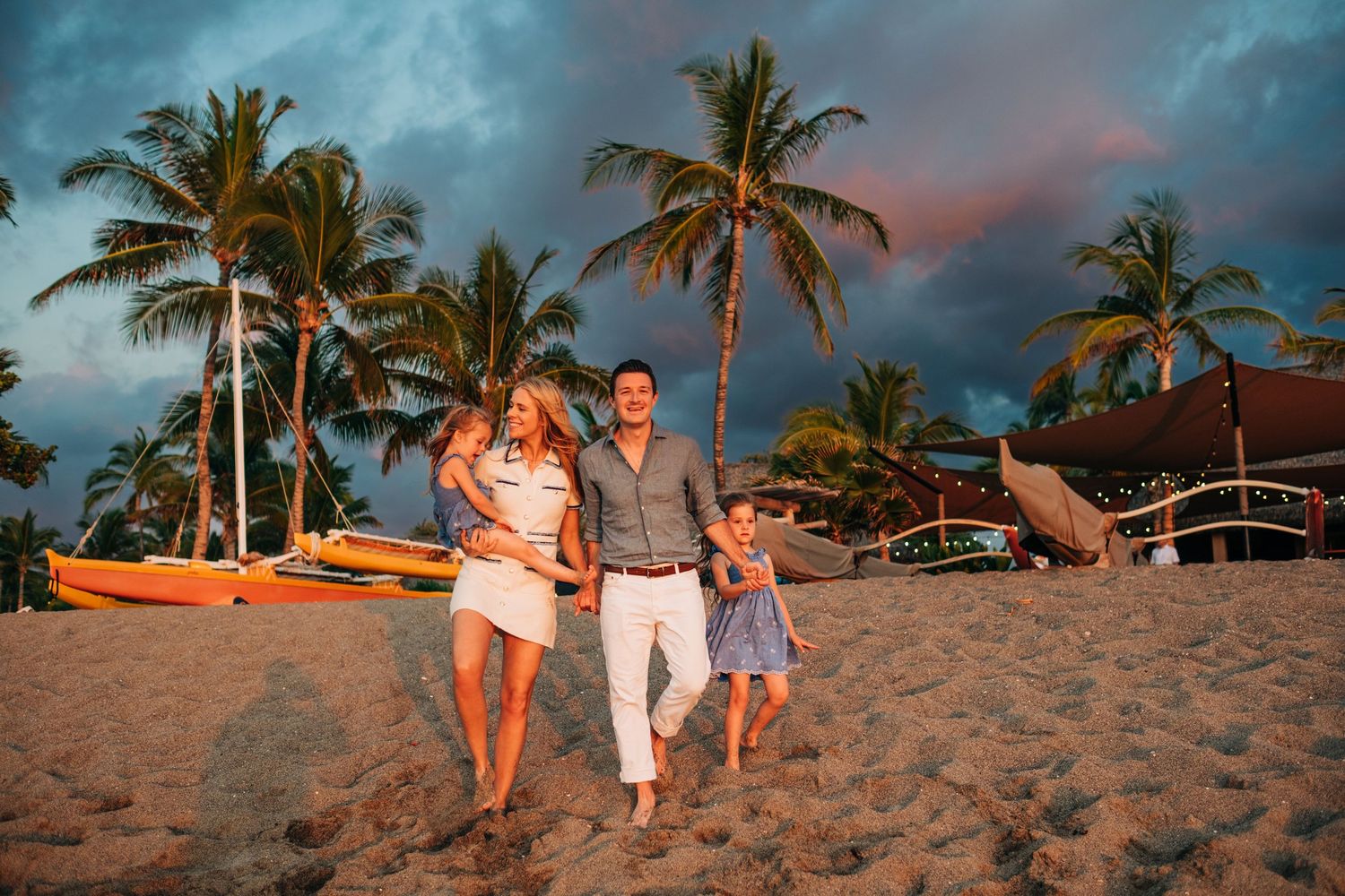 Beachside family photography session at sunset with palm trees and sand at Kona Village Resort, Big Island Hawaii.