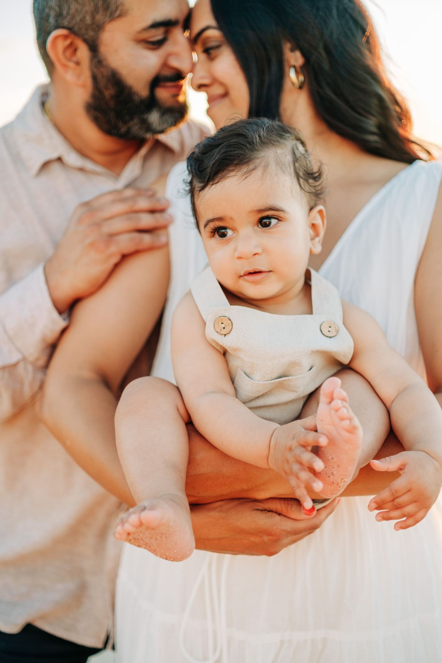 Tender family moment captured in warm sunset light with gentle expressions in Waikoloa, Big Island of Hawaii.