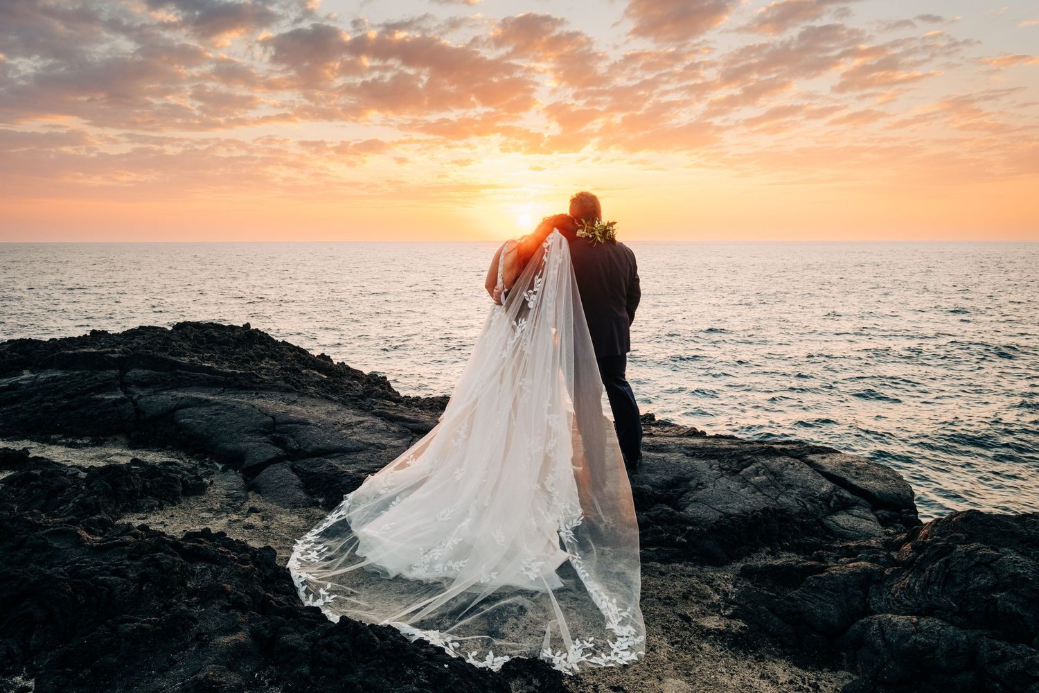 Ethereal bridal portraits on black volcanic rocks against Hawaiian ocean sunset in Kona, Big Island.