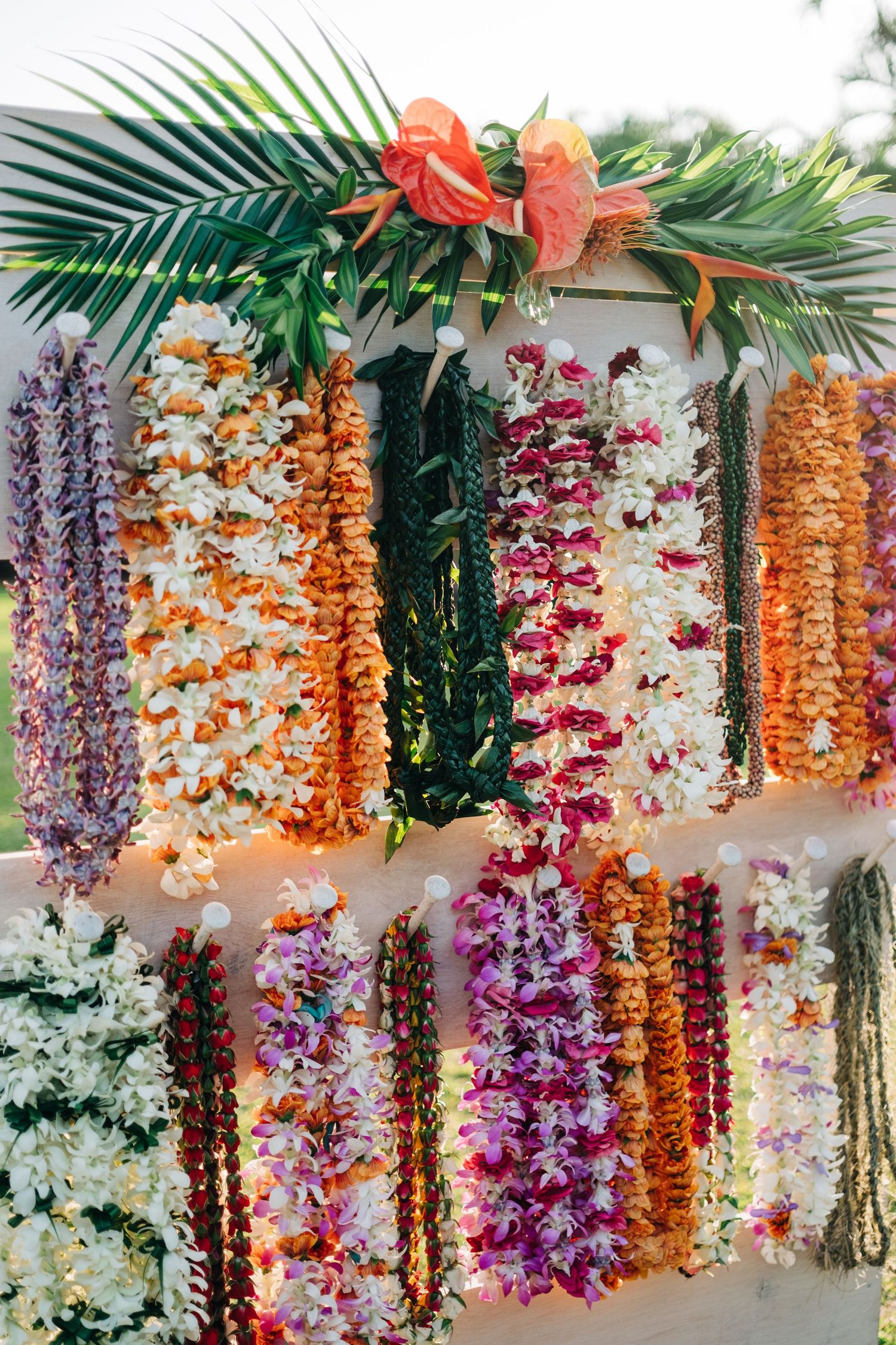 Colorful floral wall decoration with hanging orchids and tropical flowers in orange and purple hues at Mauna Lani Beach Resort.