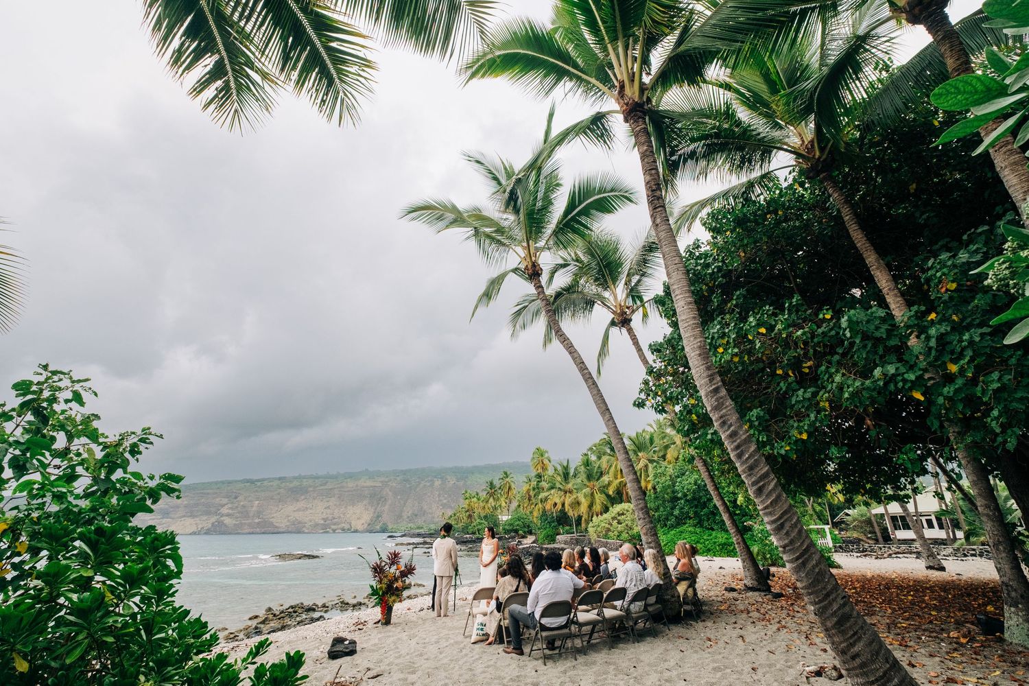 Scenic Hawaiian beach landscape with palm trees and cloudy skies in Kona, Big Island of Hawaii.