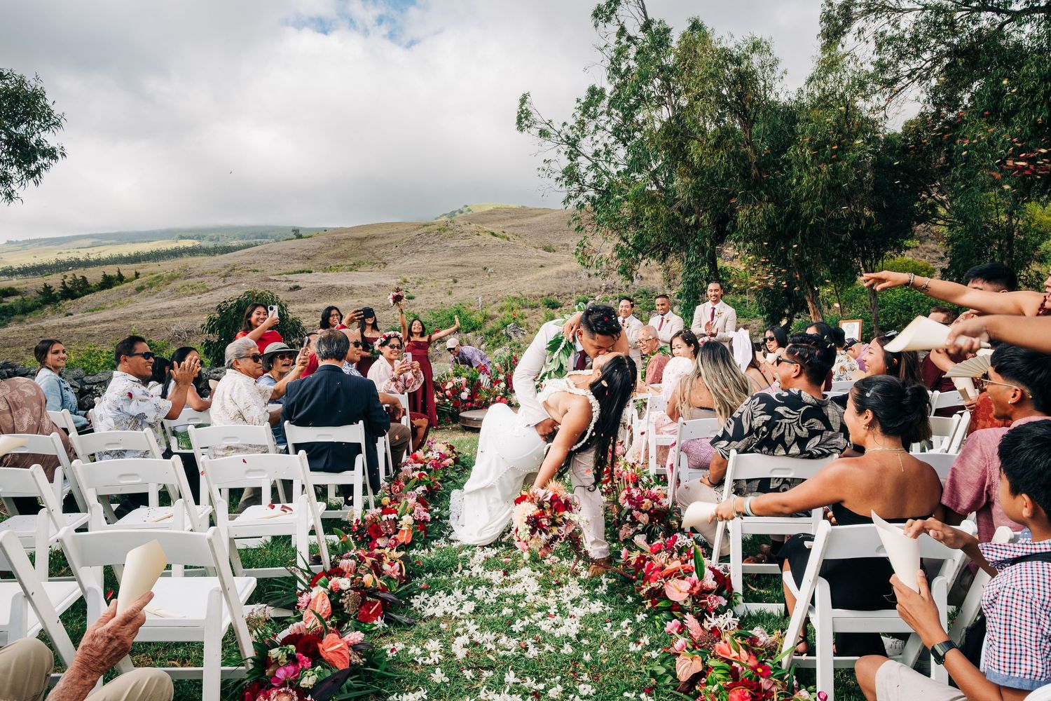 Outdoor Anna's Ranch wedding ceremony setup with white chairs and floral aisle decorations. Big Island Hawaii.